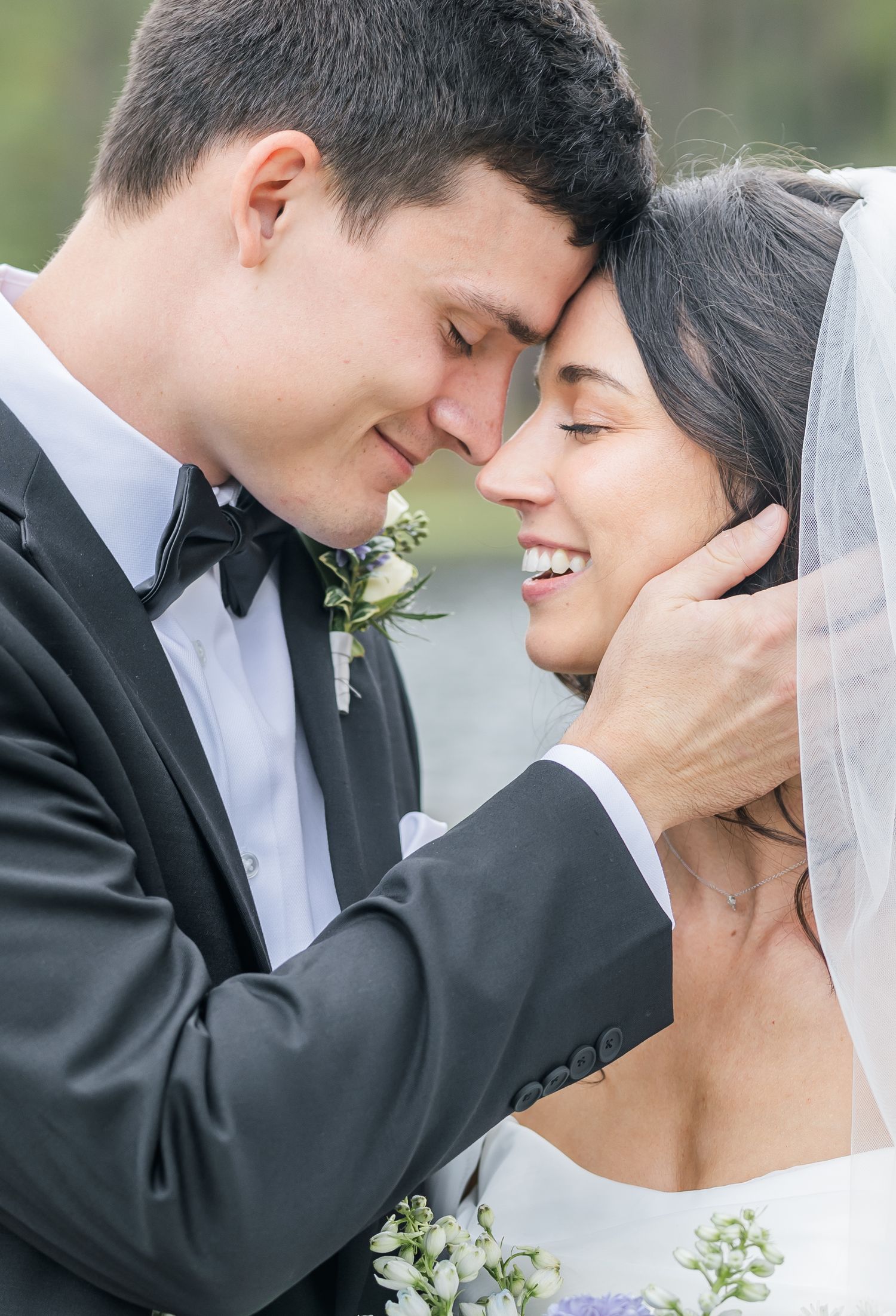 Intimate moment between newlyweds with groom tenderly holding bride's face.