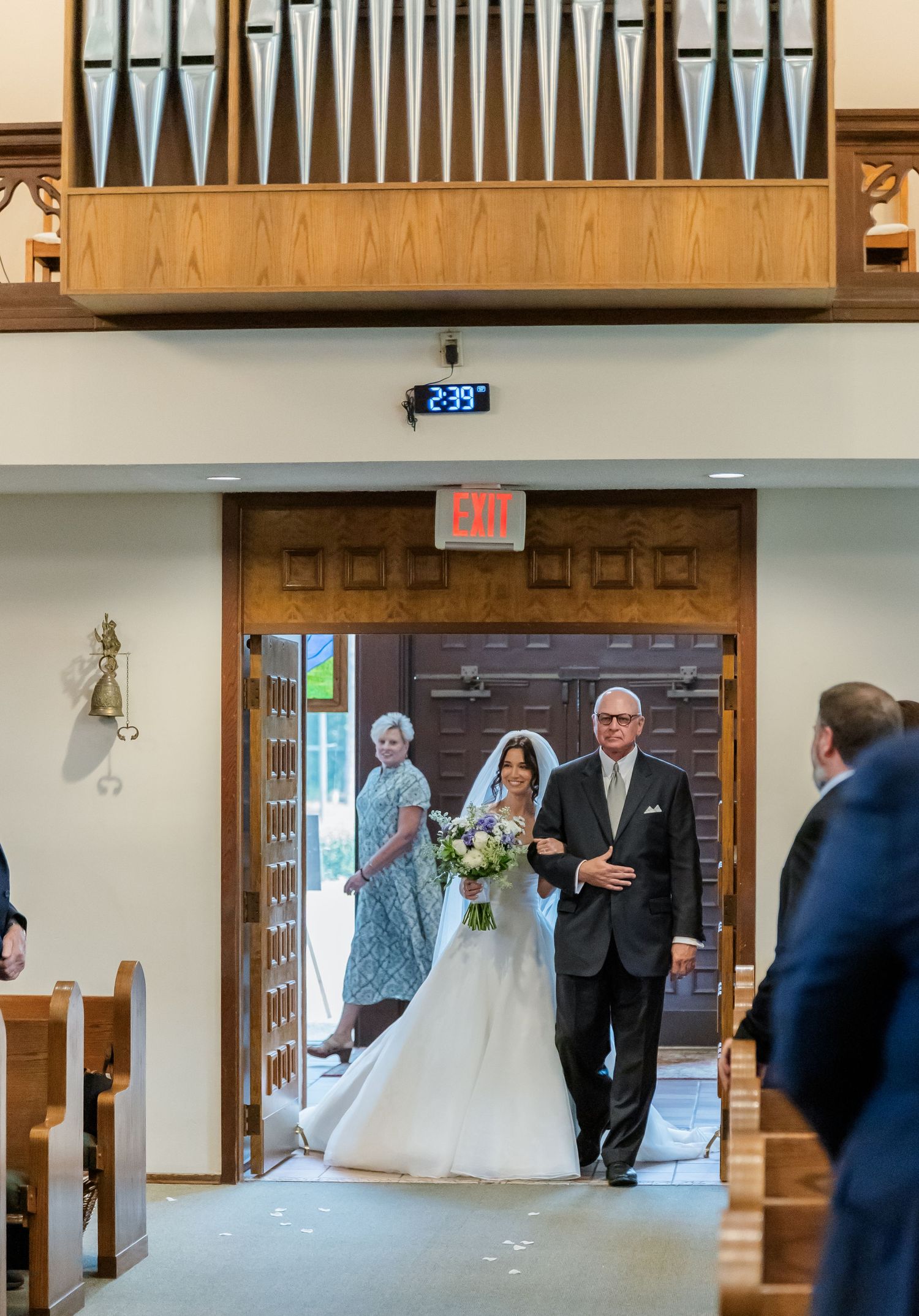 Church interior with pipe organ and wooden details during ceremony.