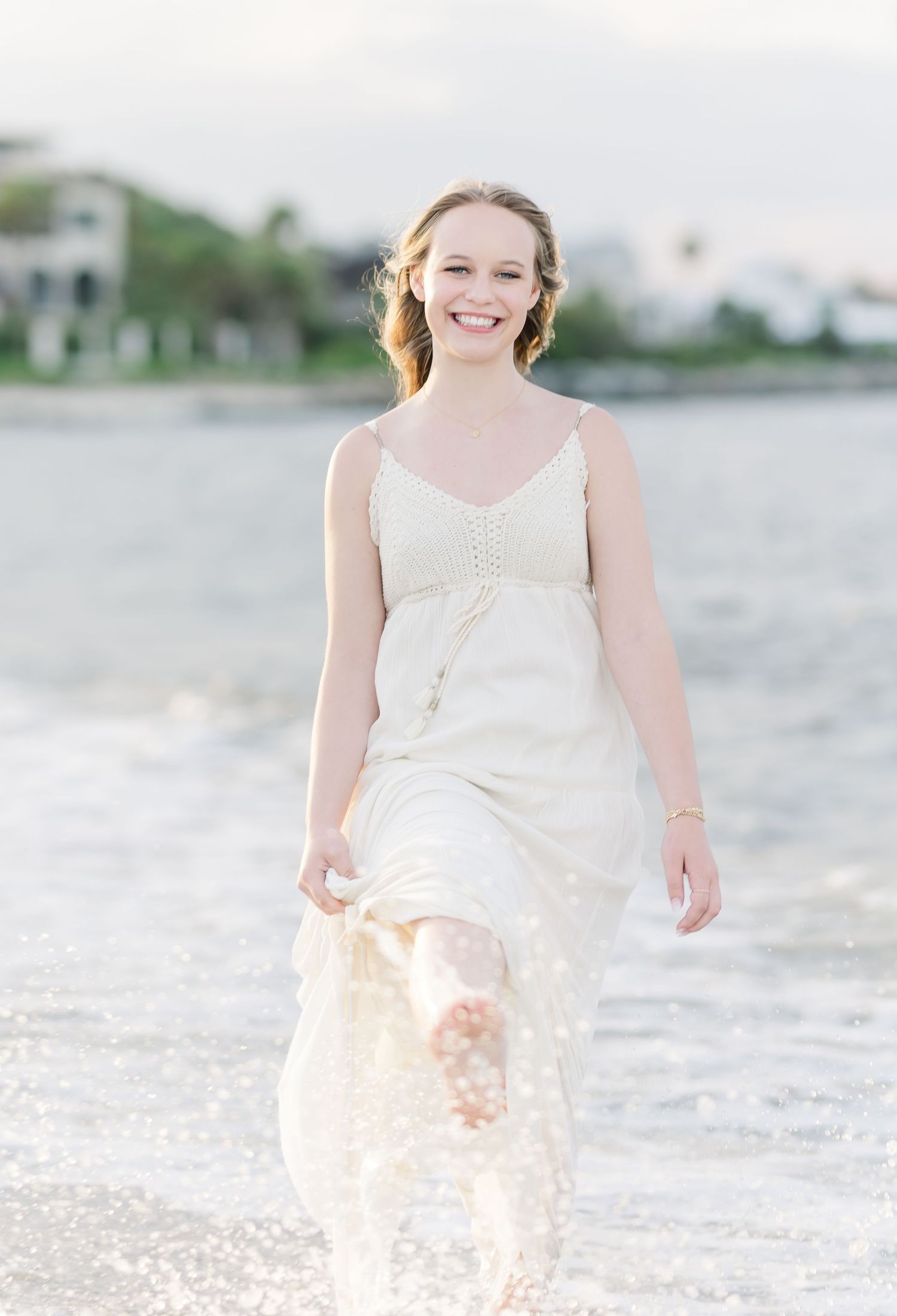 Flowy white sundress captured in soft beach lighting during golden hour.