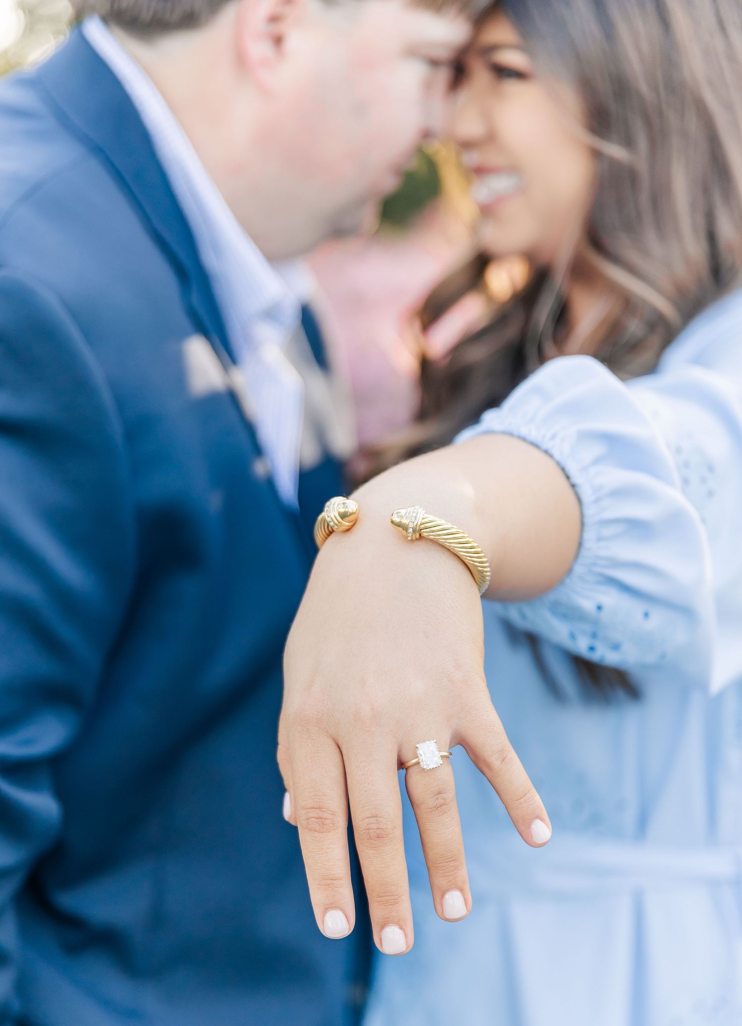 Close-up of an engagement ring and bracelet on a hand during a romantic moment.