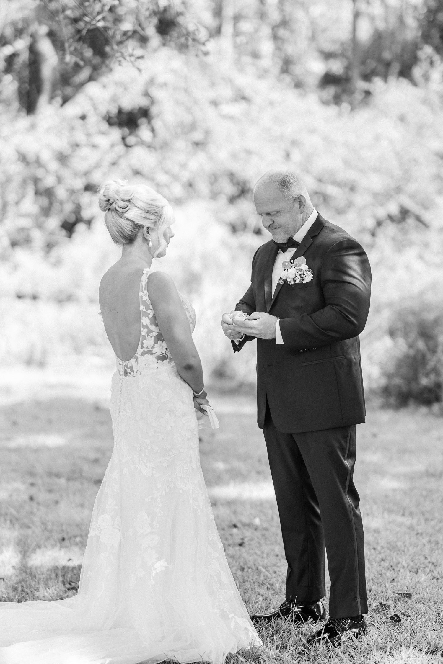 A couple exchanges rings during an intimate outdoor wedding ceremony.