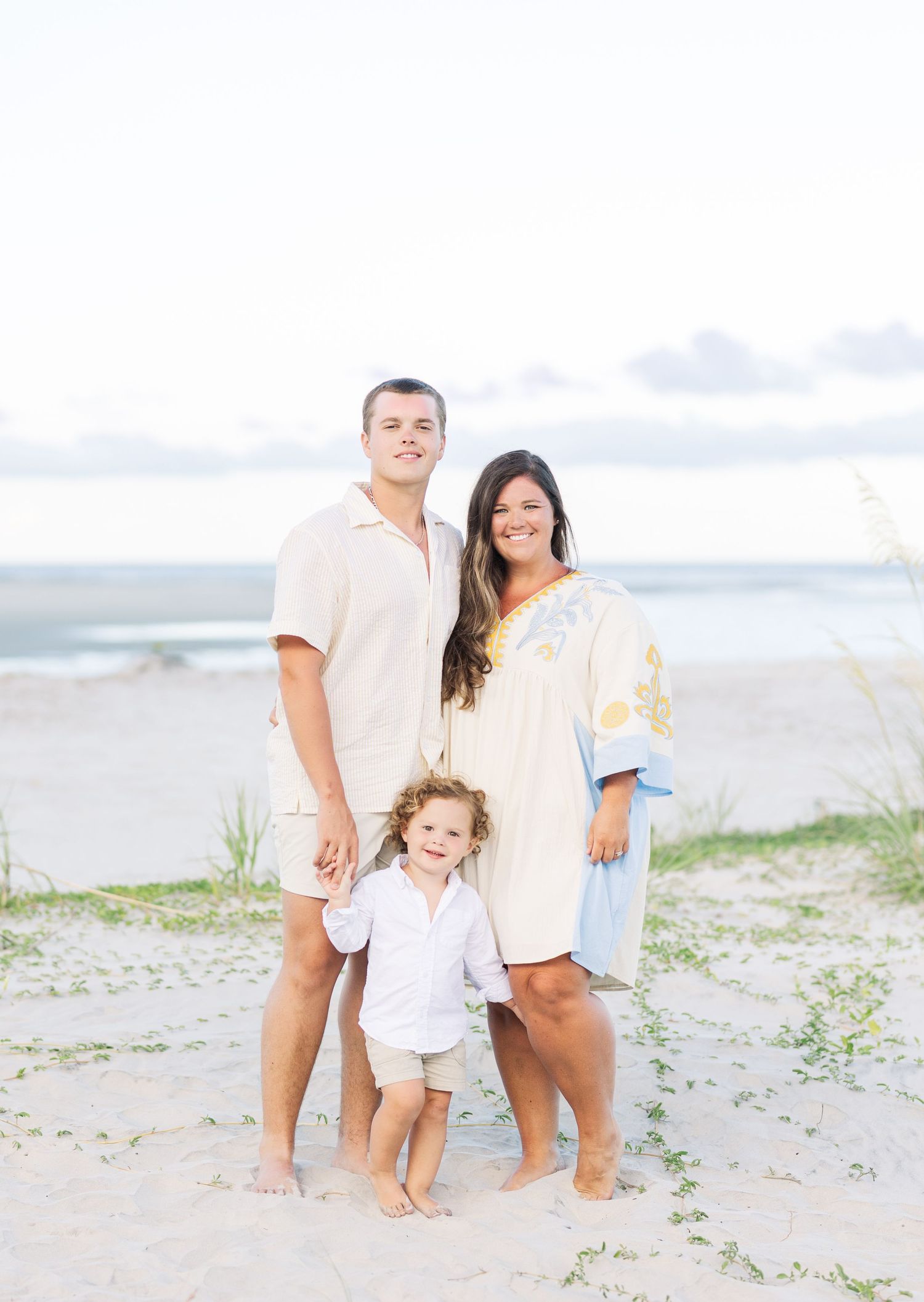 Family members laughing and enjoying a candid moment together on the beach.