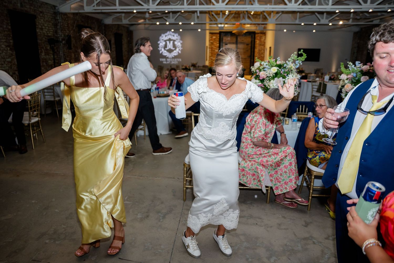 Wedding guests dance and celebrate on a reception dance floor with people in formal attire enjoying the festivities.