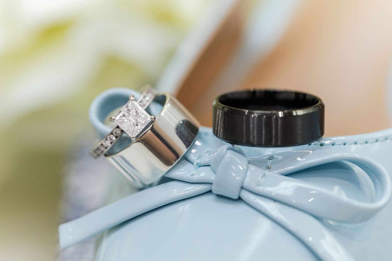 A delicate light blue bow adorns a wedding dress, featuring a sparkling diamond ring perched on its silky fabric.