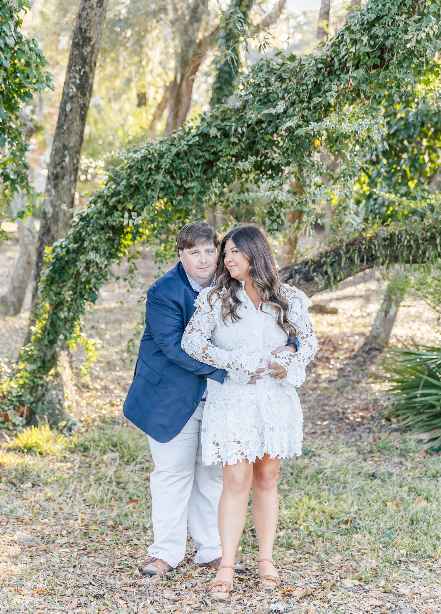 Couple sharing an intimate moment under moss-draped trees.