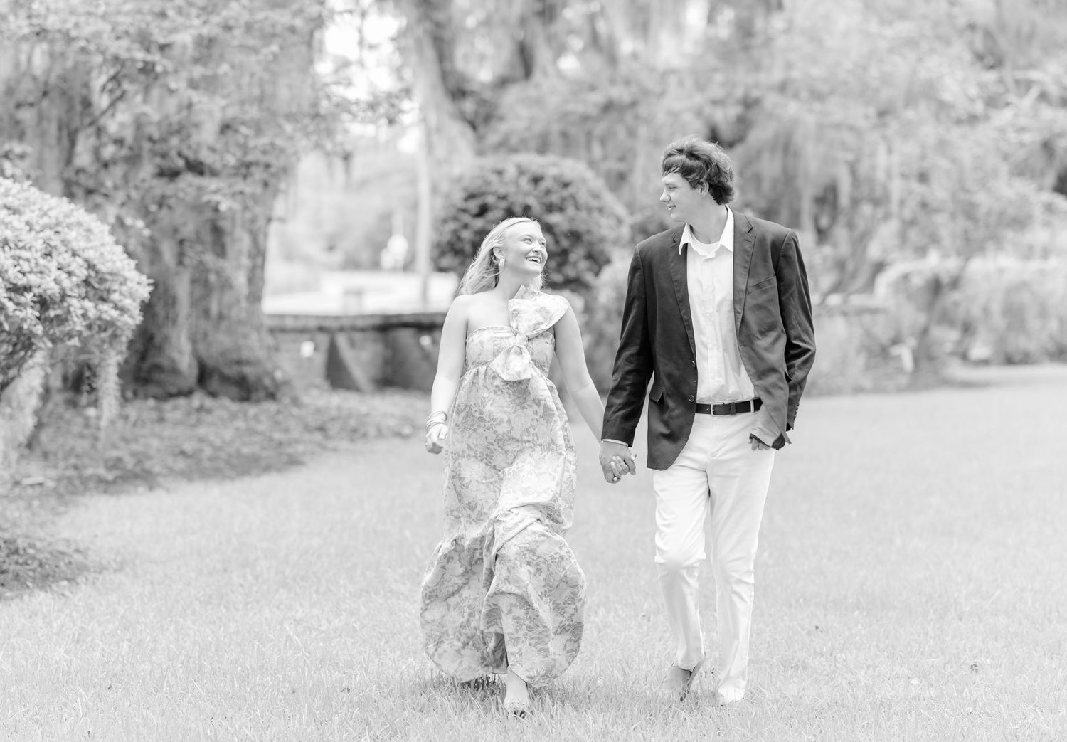 Black and white wedding photo series showing couple walking together in outdoor garden setting.
