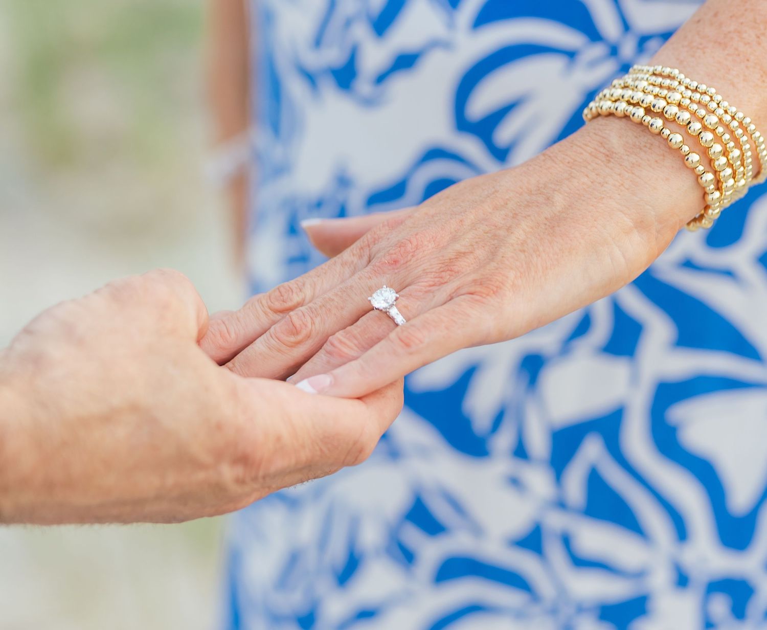 A sequence of close-up photos showing hands with engagement rings against a blue and white patterned background.