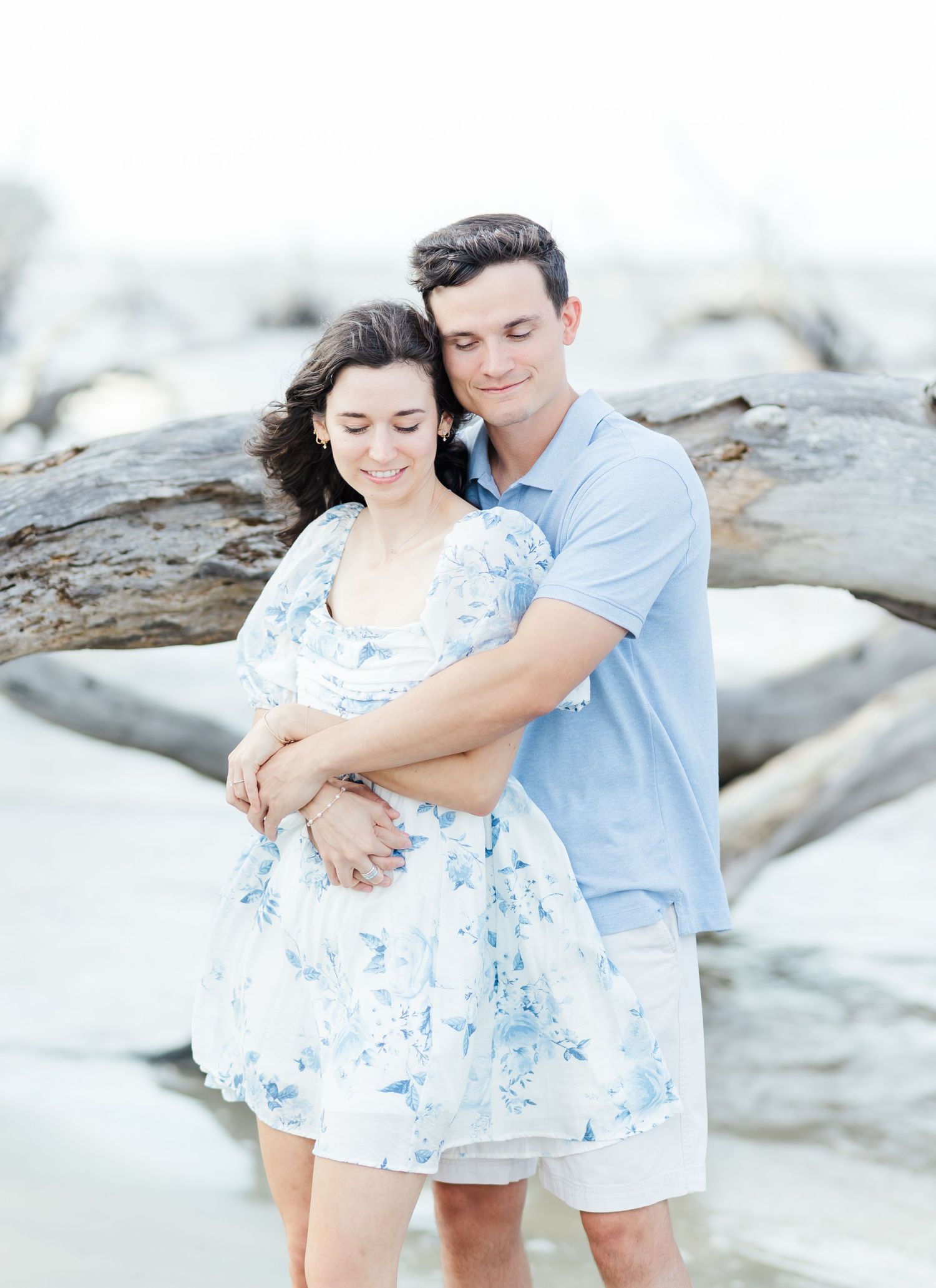 A sweet moment captured between a couple in matching blue tones on a bright beach setting.