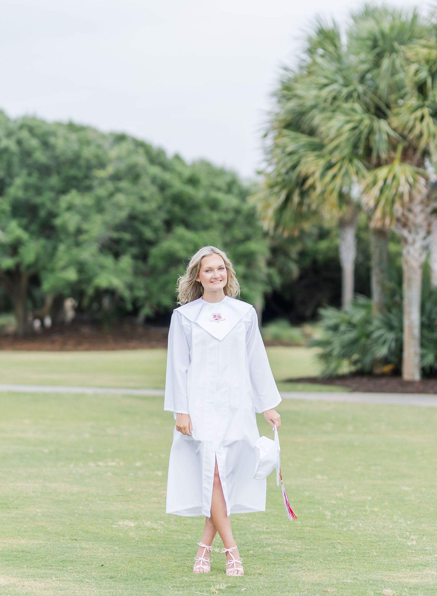 Multiple photos taken at different distances show someone in white clothing on a green lawn with palm trees in the background.