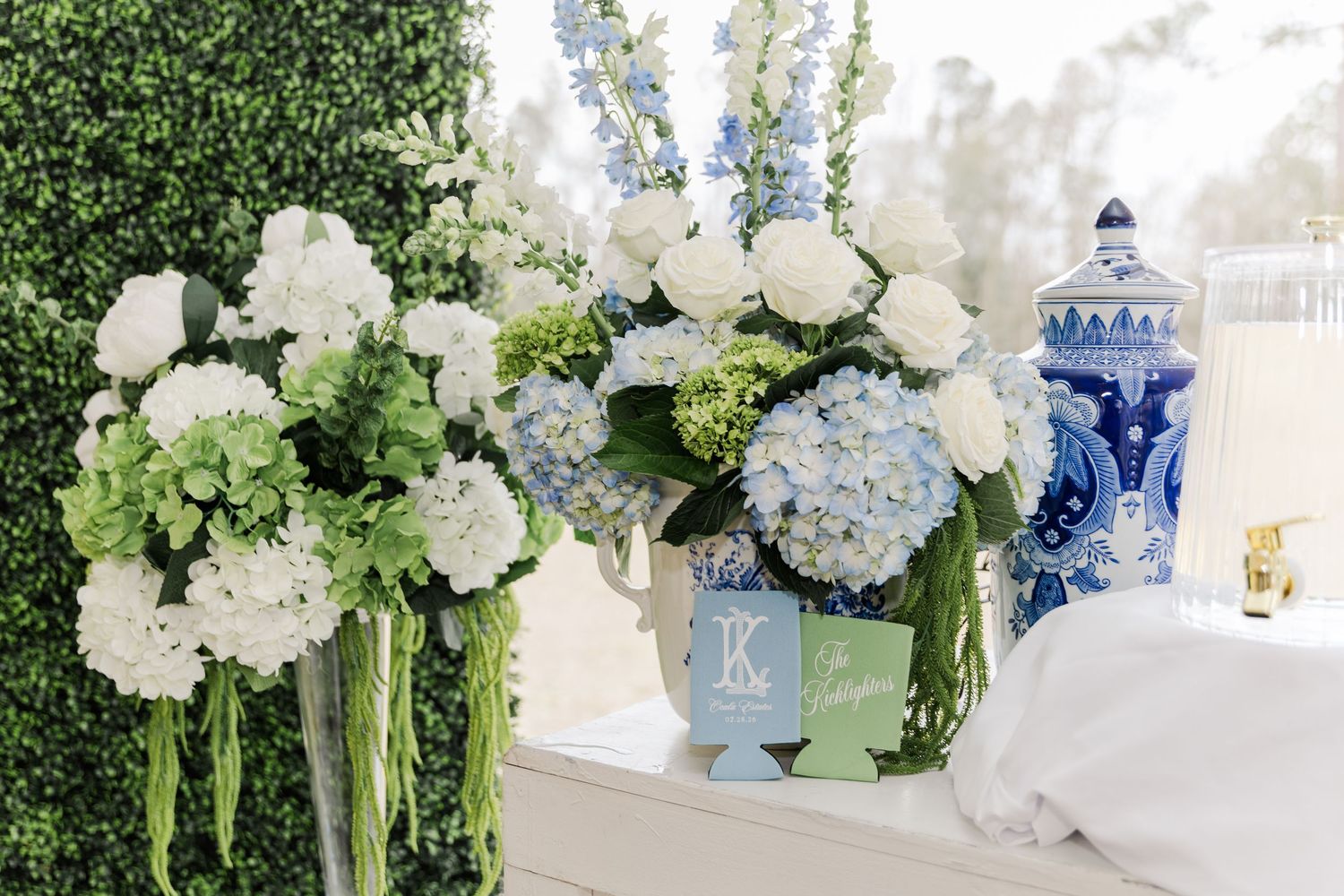 Blue hydrangea and white floral wedding arrangements with blue and white ginger jar decor.