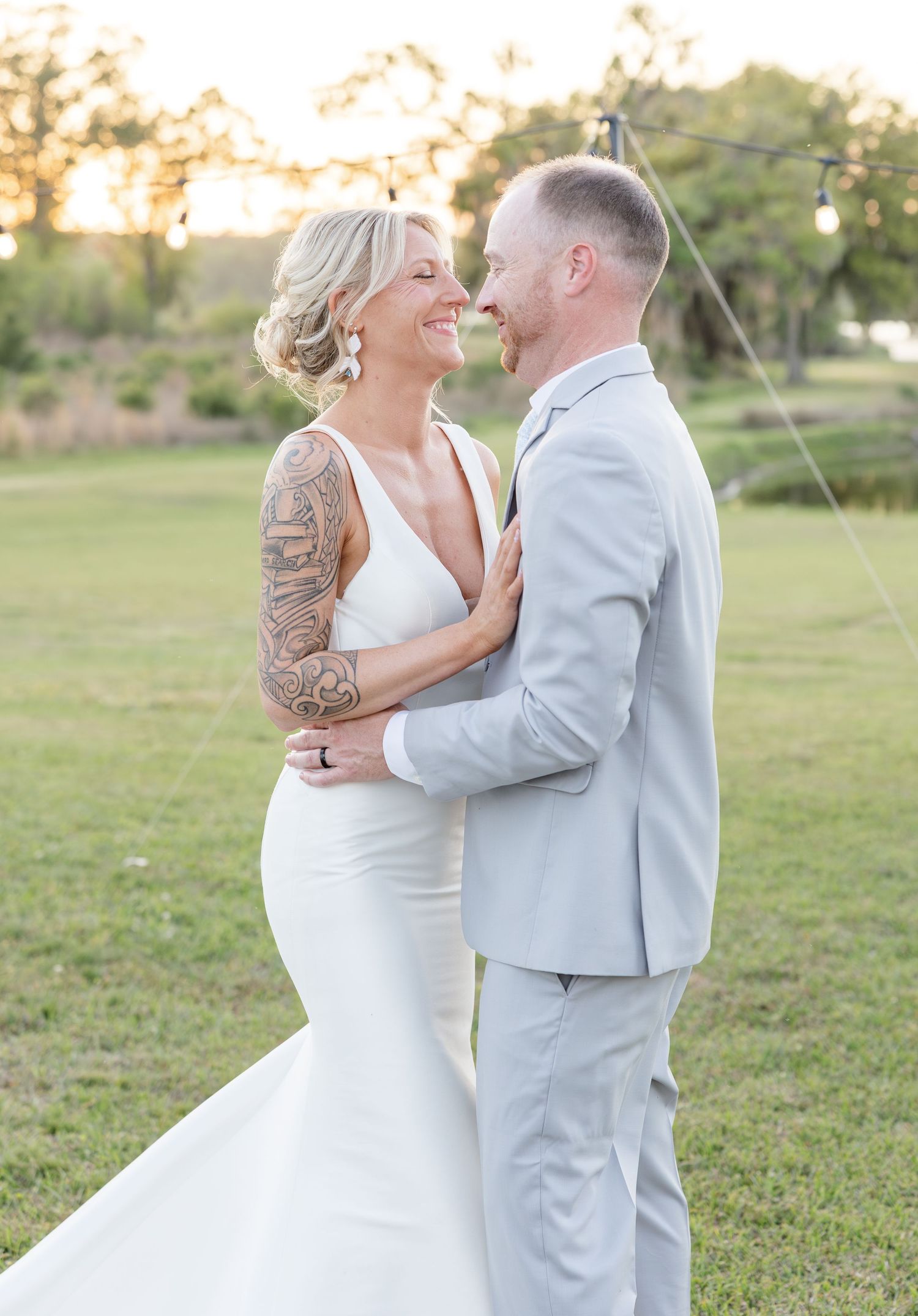 Bride and groom gazing at each other lovingly during golden hour outdoor wedding celebration.