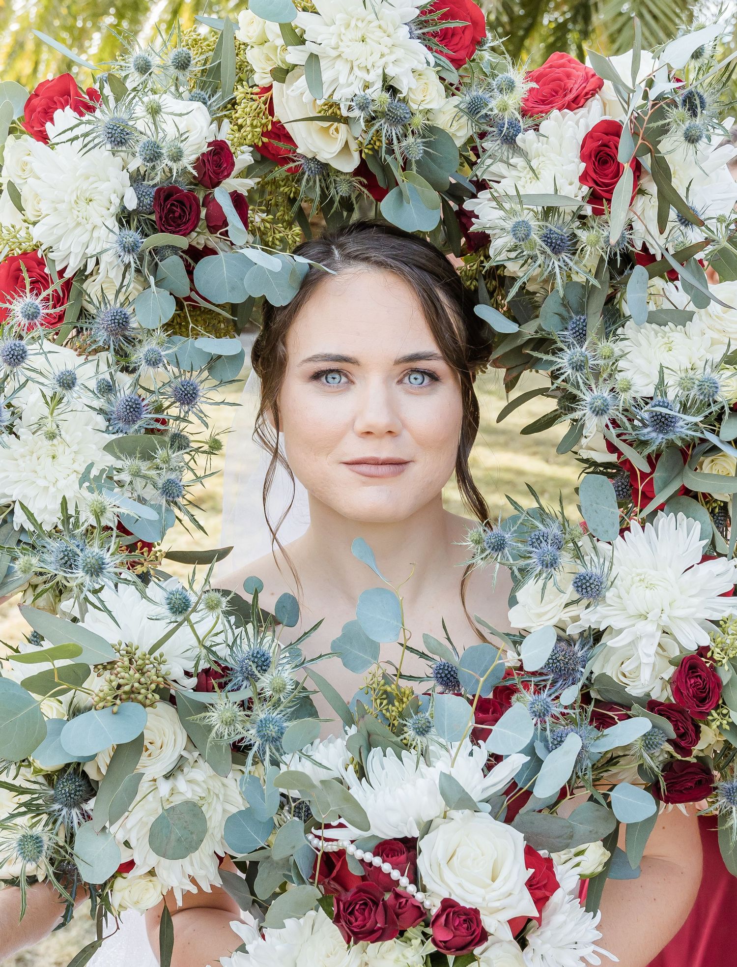 Beautiful floral arrangement with white flowers, eucalyptus, and deep red roses.