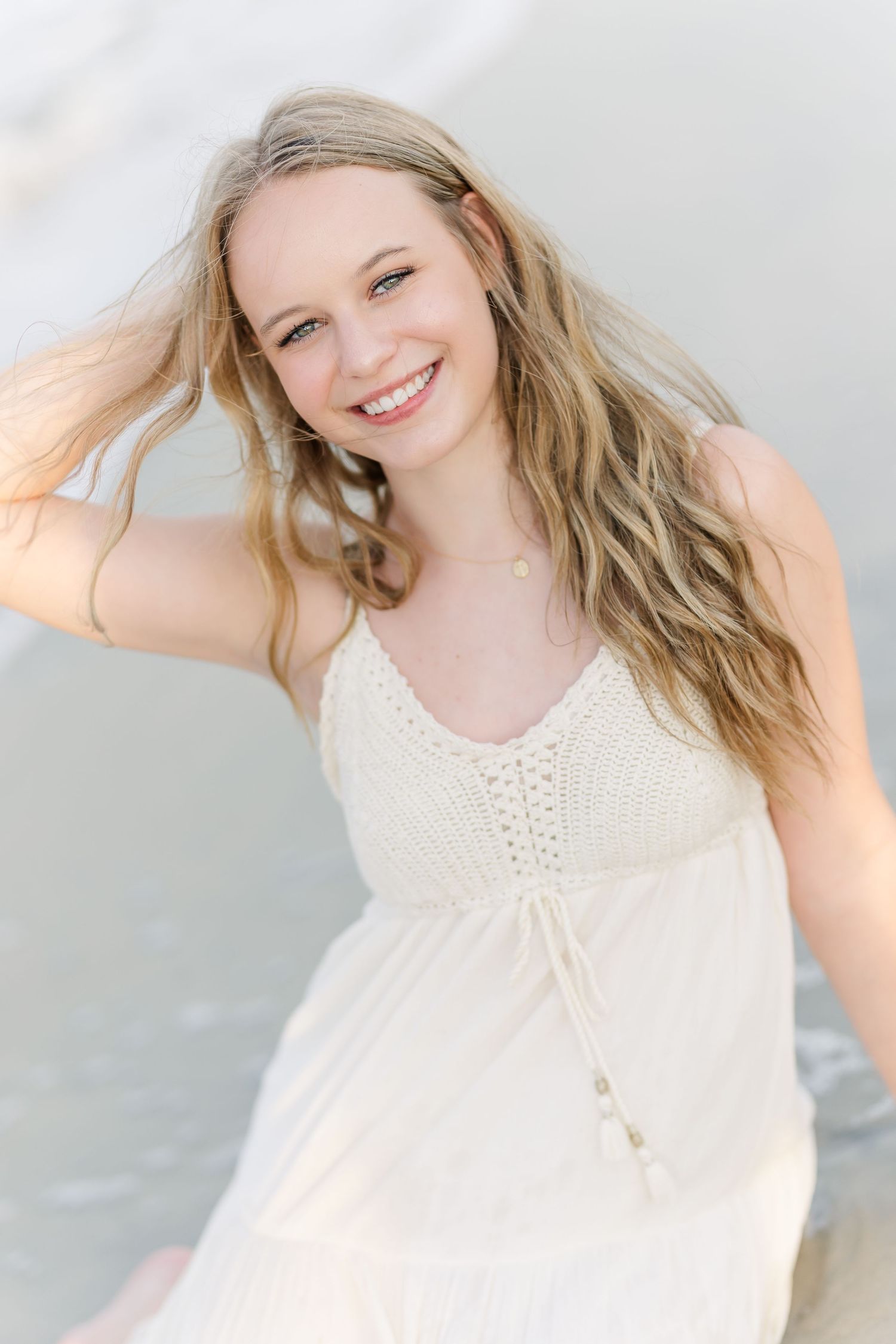 A romantic portrait in a white summer dress against a soft neutral background.