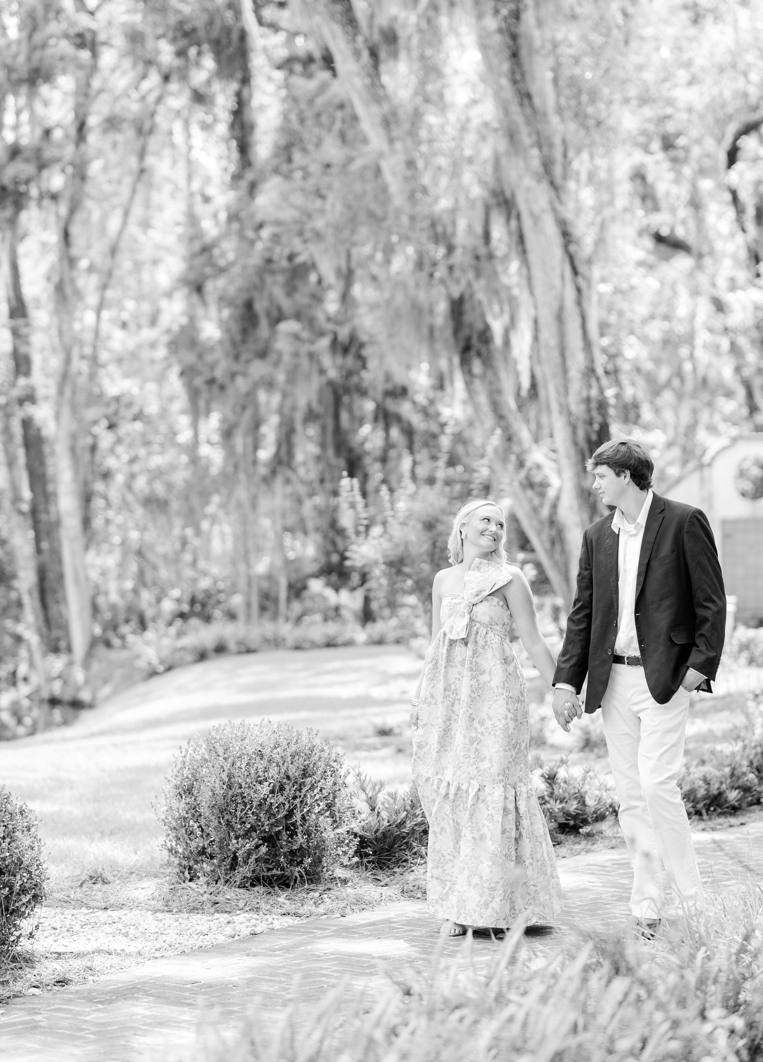 Black and white panoramic series of a couple walking through a tree-lined path.