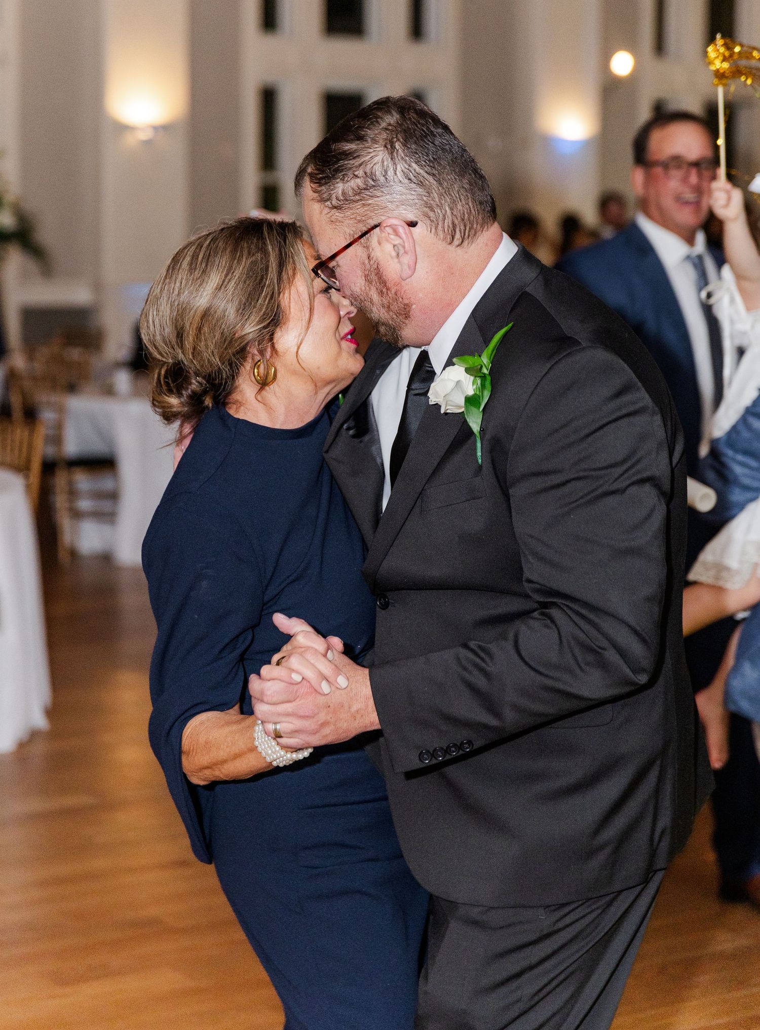 Groom shares a tender dance and kiss with his mother at the wedding reception.