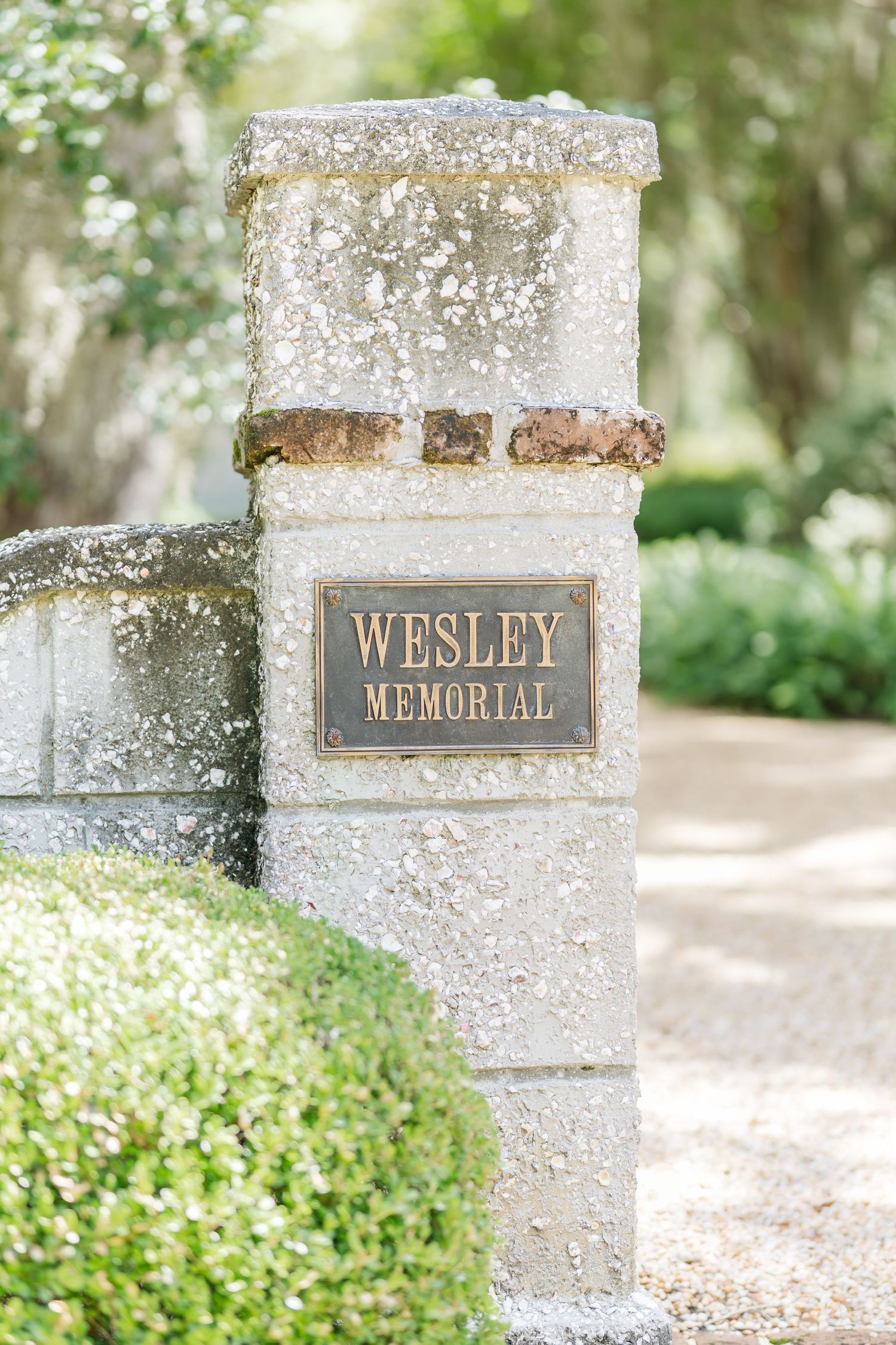 Gray stone memorial pillars with metallic name plates reading 