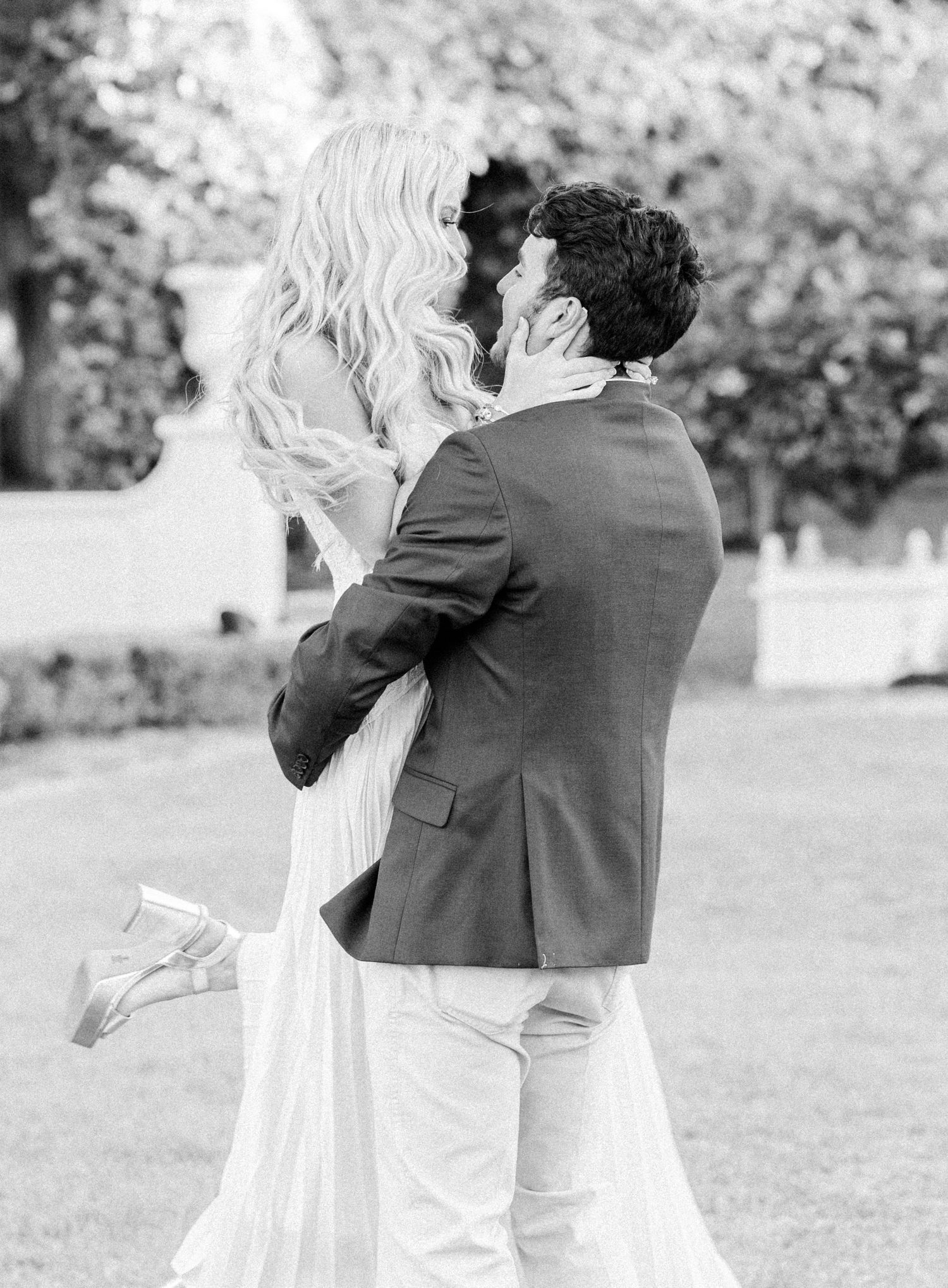 Black and white wedding photos showing a couple dancing and embracing in an outdoor garden setting.
