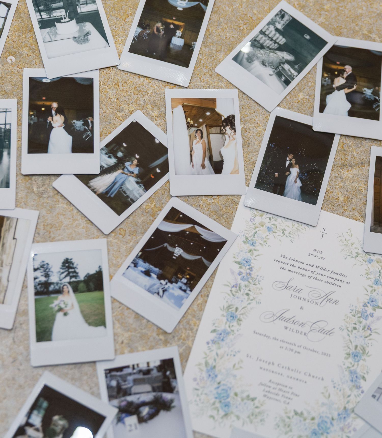 A collection of vintage-style Polaroid wedding photos scattered on a beige surface with a floral invitation card.