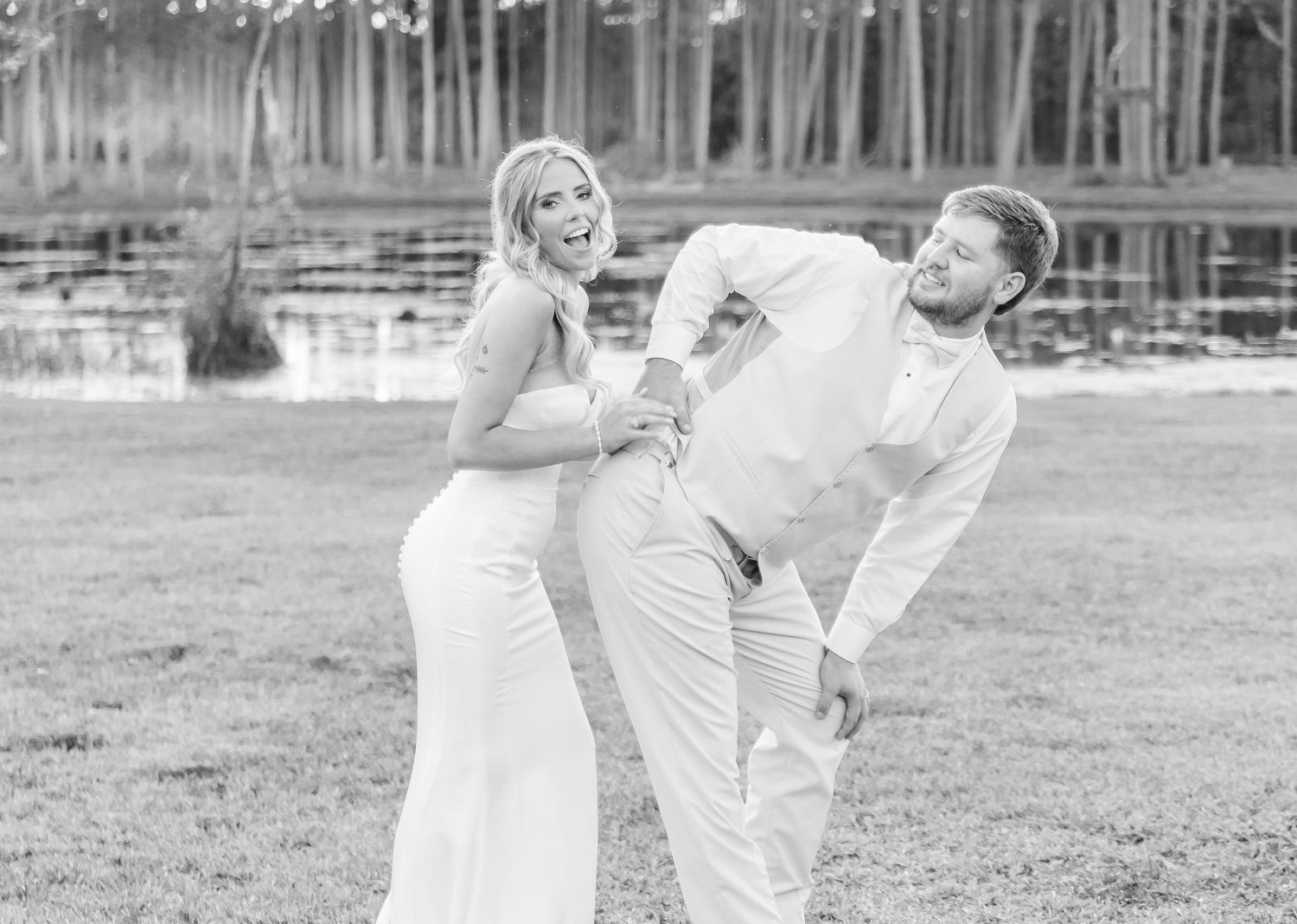 Lighthearted black and white photo of newlyweds sharing funny moment during photoshoot.