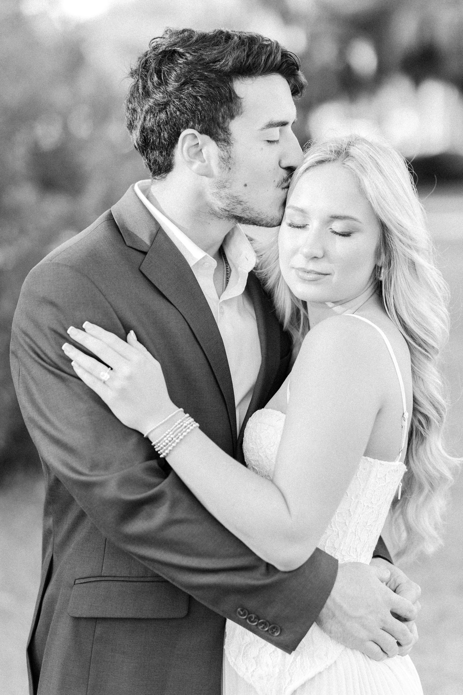 Black and white romantic wedding photos showing tender moments between a couple in formal attire.