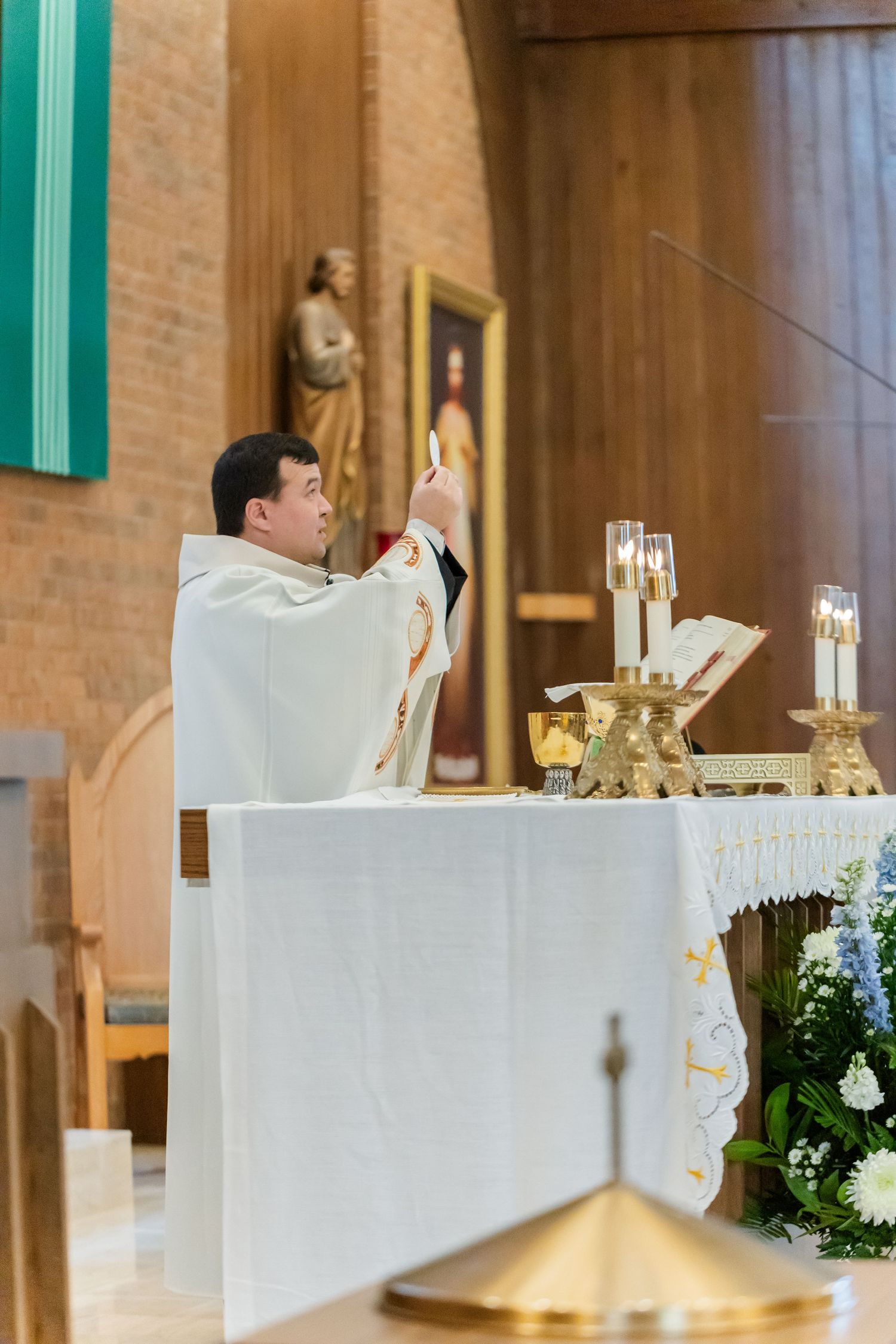 An elegant church altar decorated with white linens and floral arrangements for a wedding ceremony.