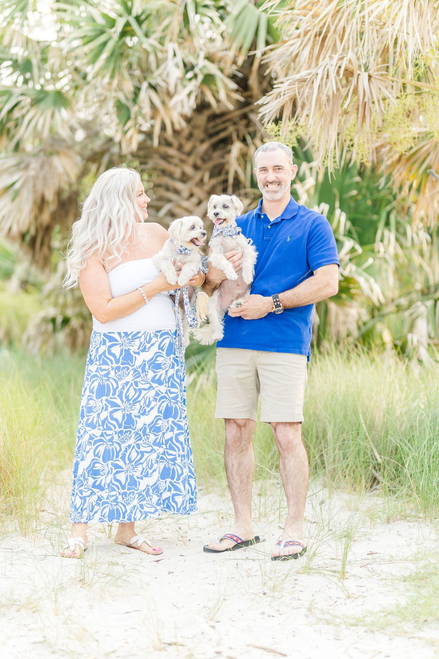 Series of candid beach photos showing a couple enjoying time with their small white dog by the palms.