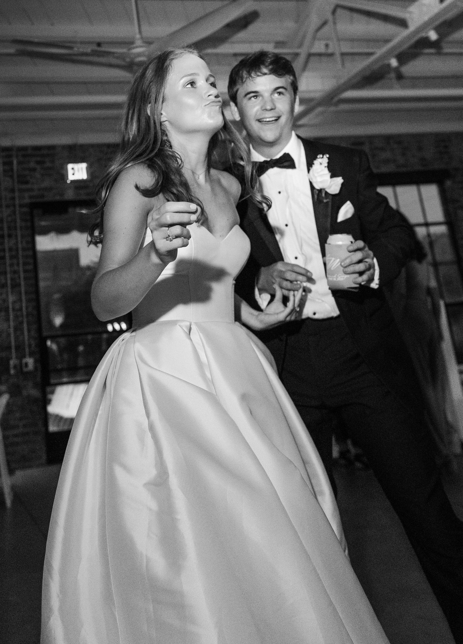Bride and groom share a romantic first dance in black and white photo at their wedding reception.