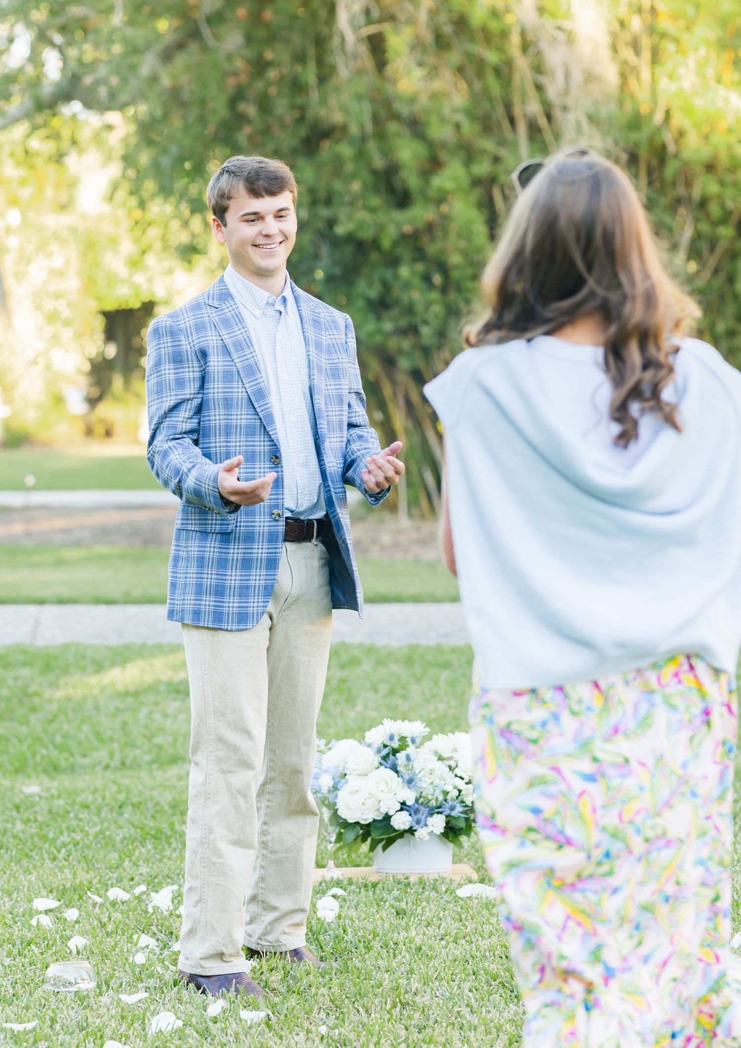 A couple in a garden setting shares a romantic moment with a white shawl during a spring photo session.