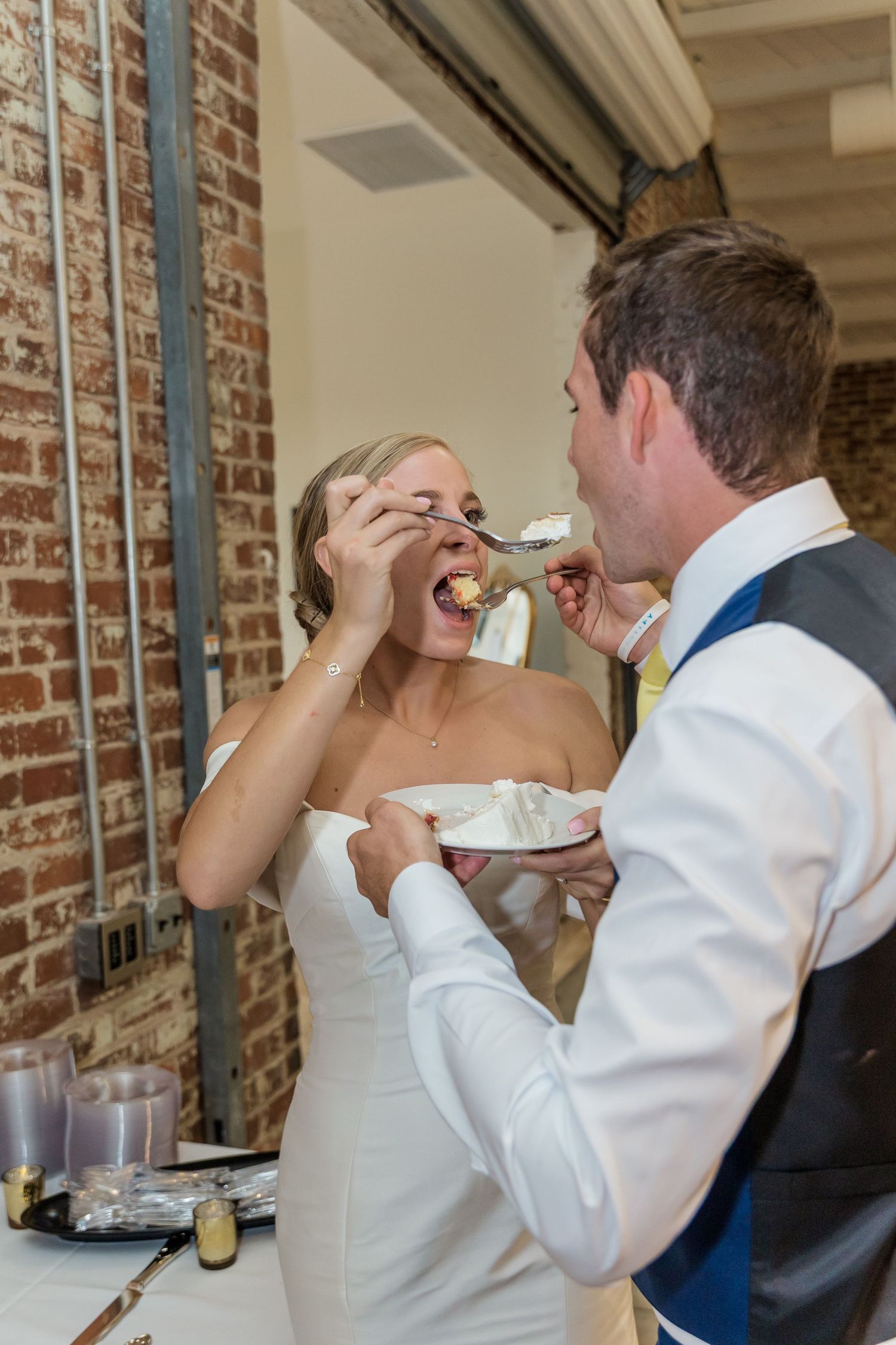 A couple feeds each other wedding cake in a series of four sequential photos showing the traditional cake cutting moment.