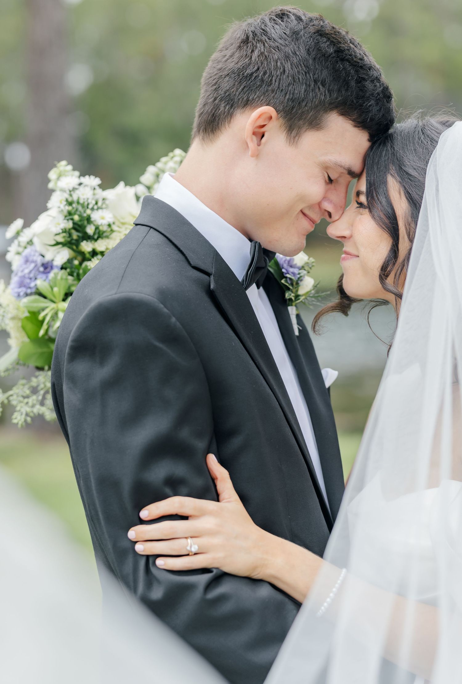 A romantic wedding photo series showing tender moments between a bride and groom in formal attire with white floral decor.