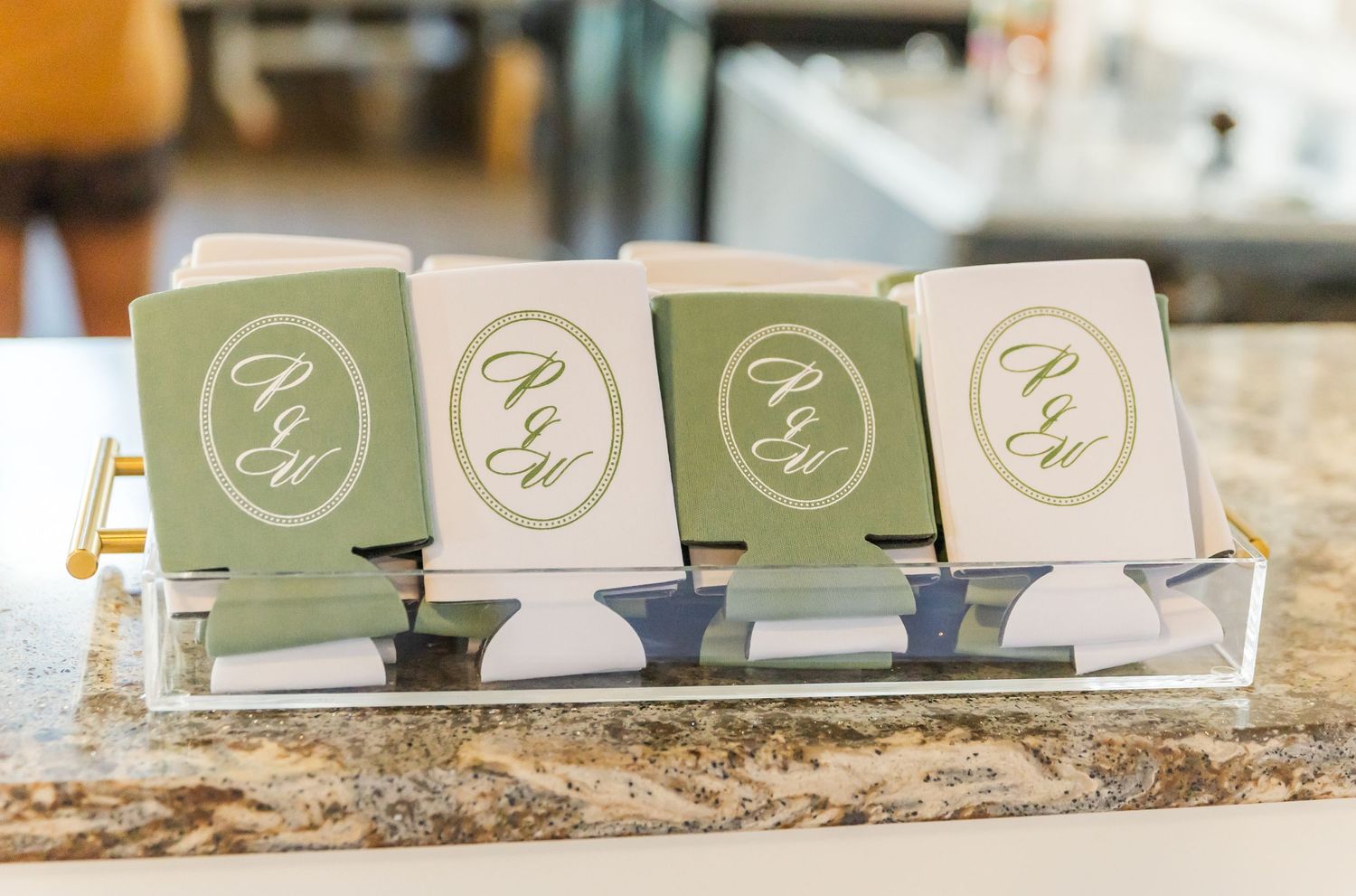 Row of sage green and white wedding place cards displayed on textured surface.