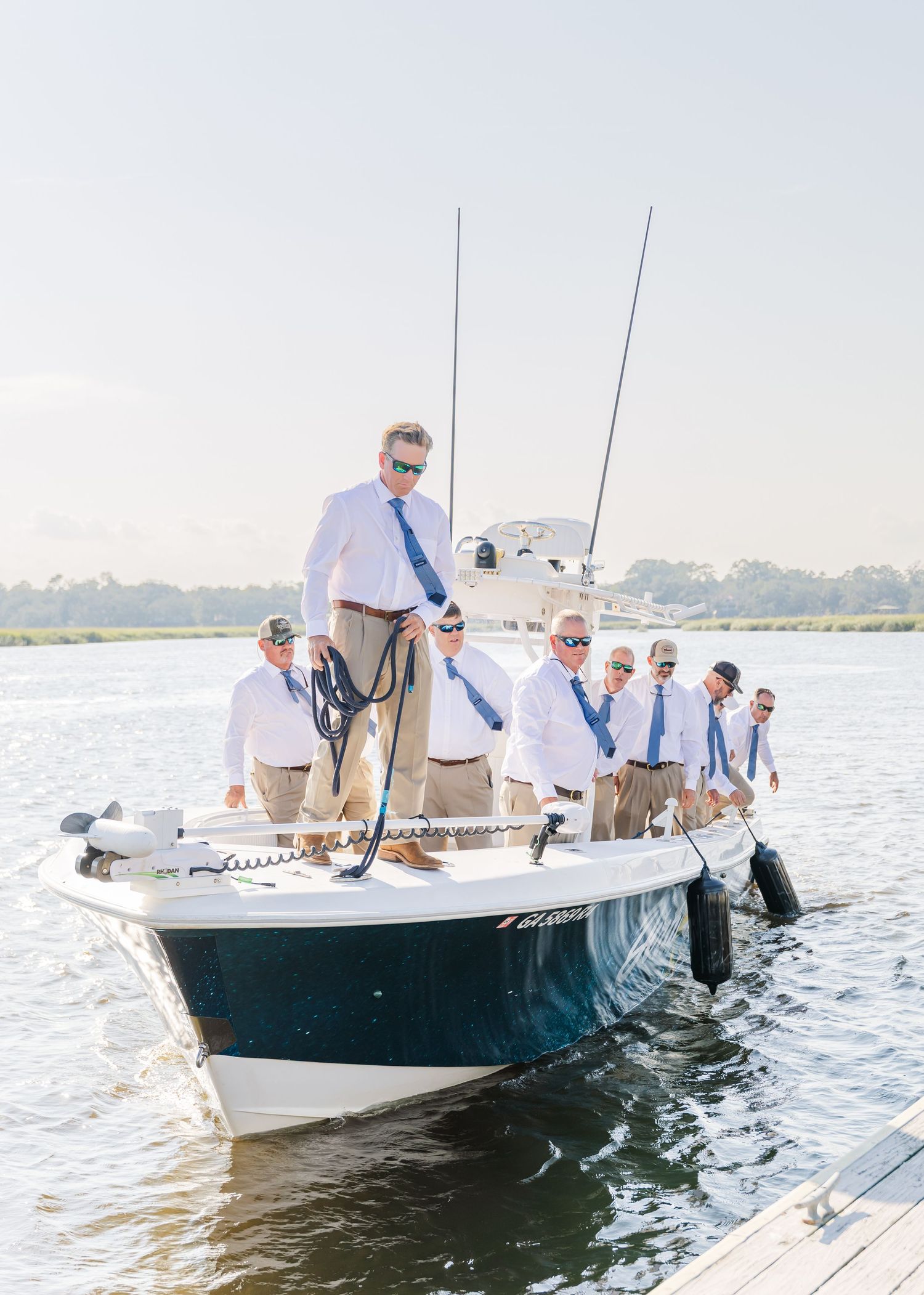 Group of people aboard fishing boats on calm waters during a sunny day.