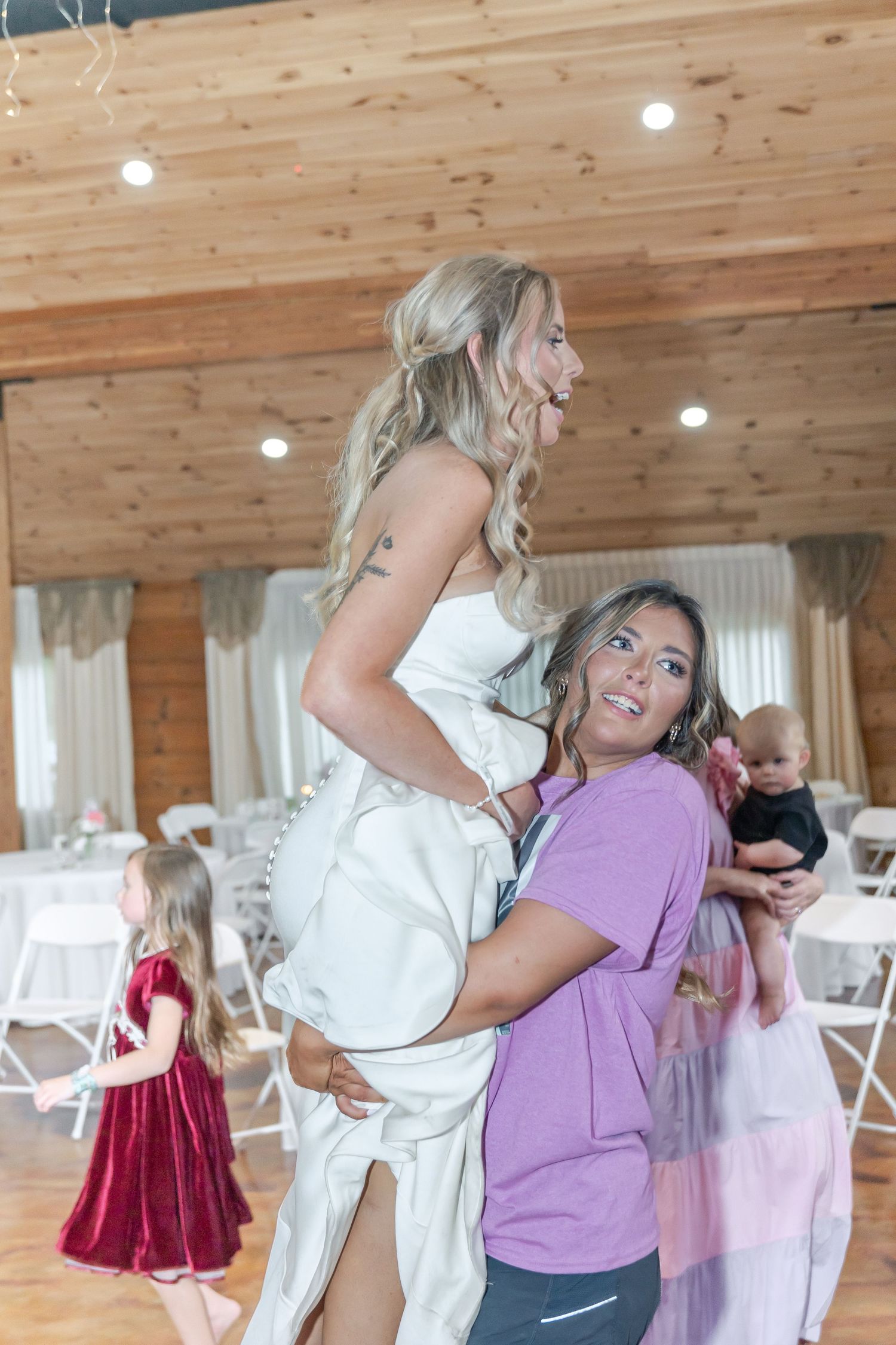 Joyful wedding reception moment showing celebration inside rustic wooden venue.