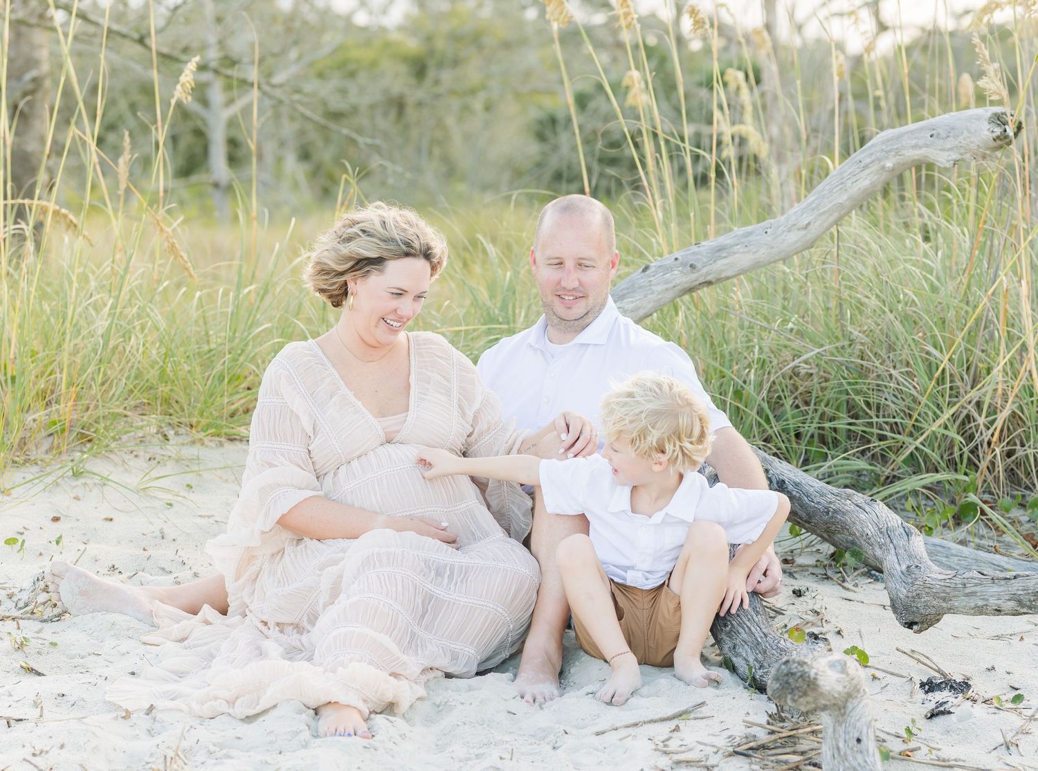 Natural outdoor family photography session among sea grass and sandy dunes.