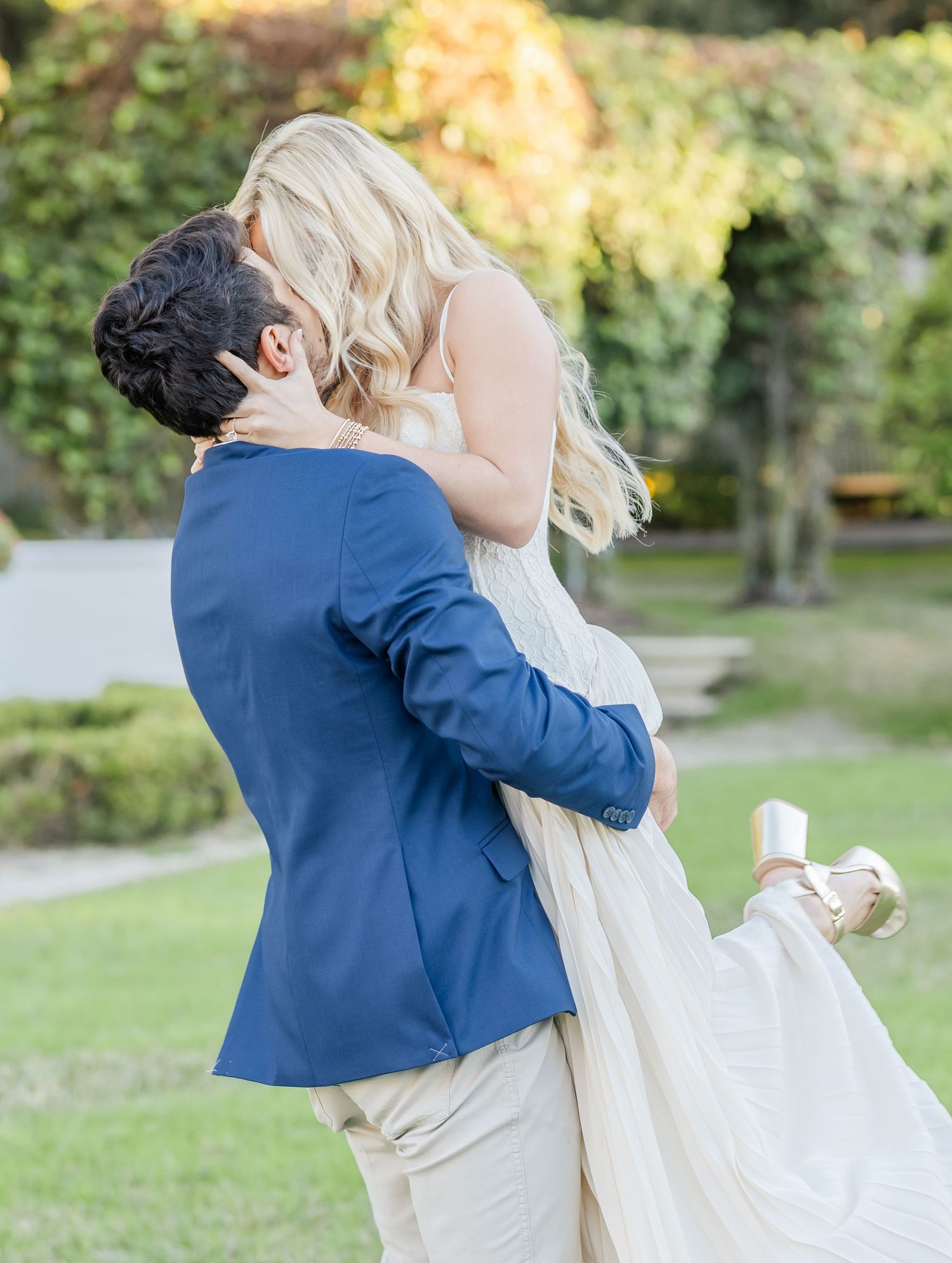 A romantic embrace between a couple outdoors, with the person in blue dipping their partner in white.