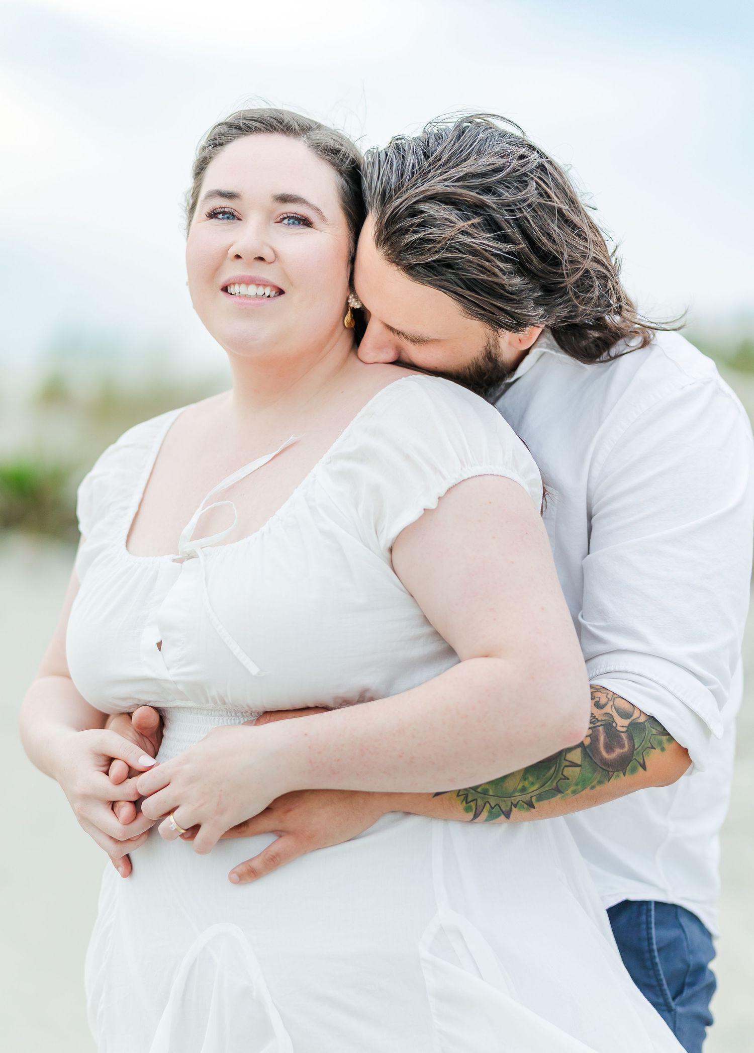 Tender embrace captured during a romantic beach portrait session.