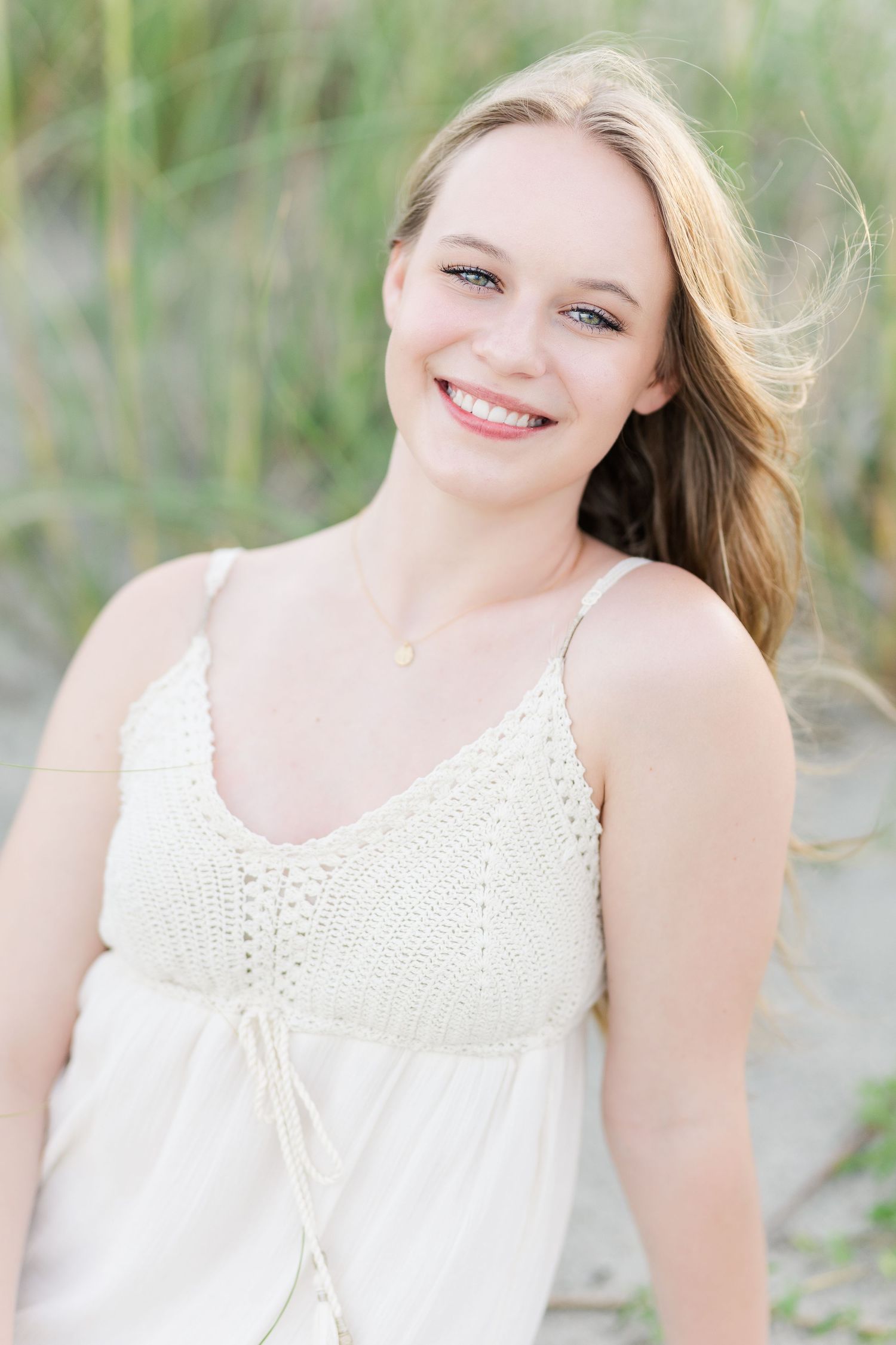 Soft white crochet top summer portrait with beach grass and natural lighting.