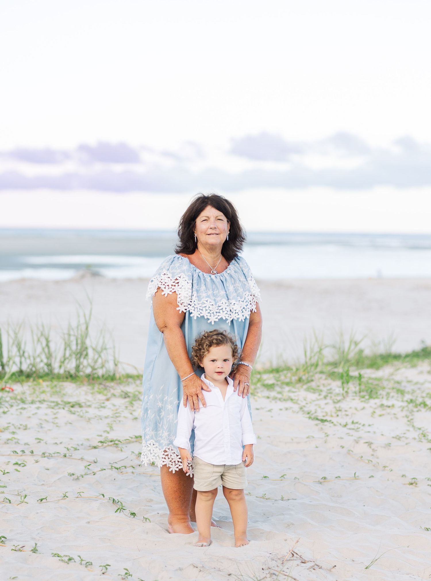 Multi-generational family enjoying a candid moment on a sunny beach.