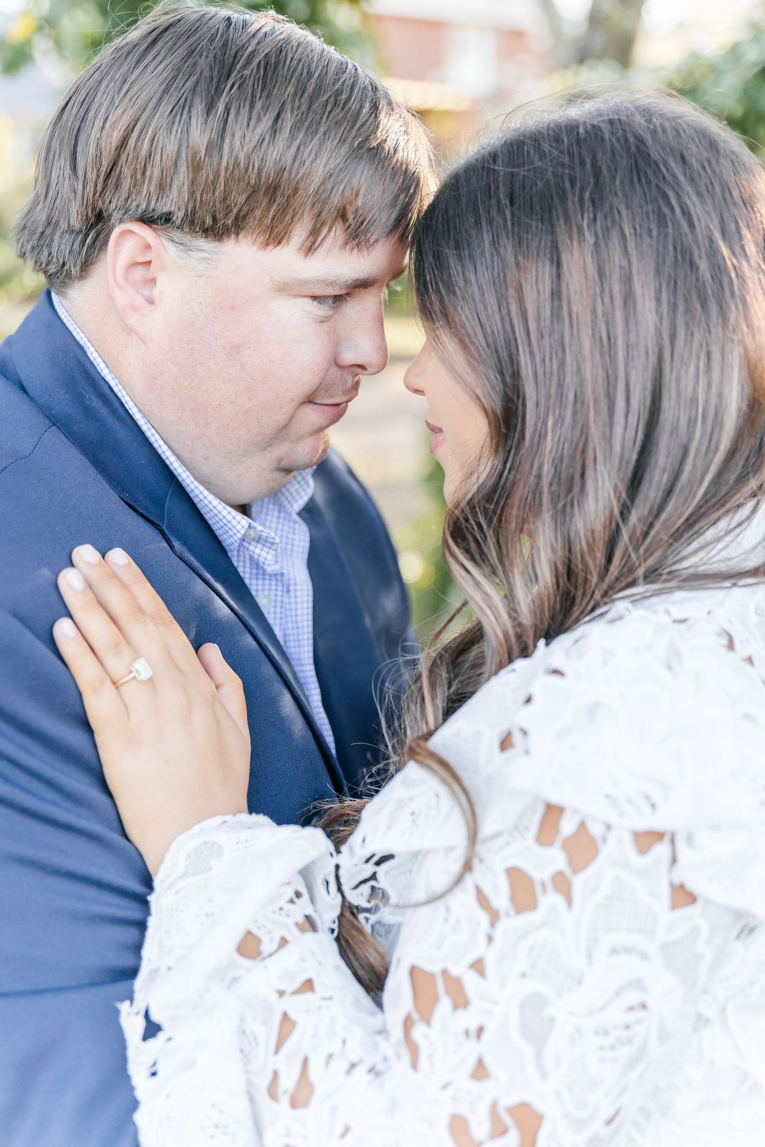 A couple in formal attire sharing a romantic moment outdoors.