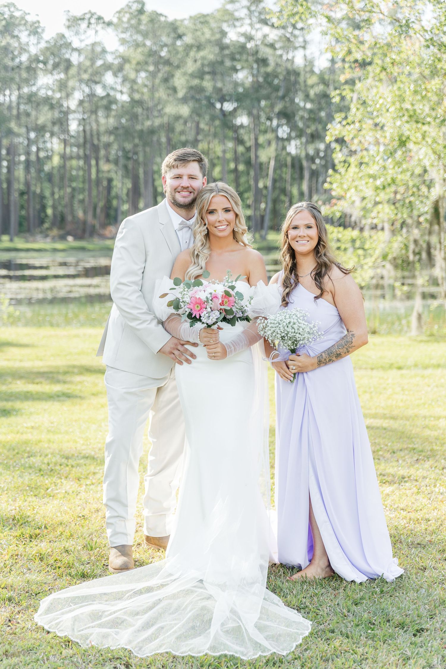 Light and airy wedding portrait with bridal party in white and lavender against natural backdrop.