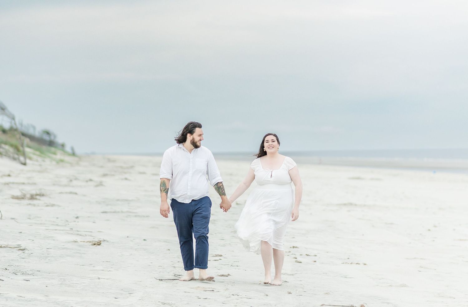 Couple enjoys a carefree walk together on a pristine white sand beach.