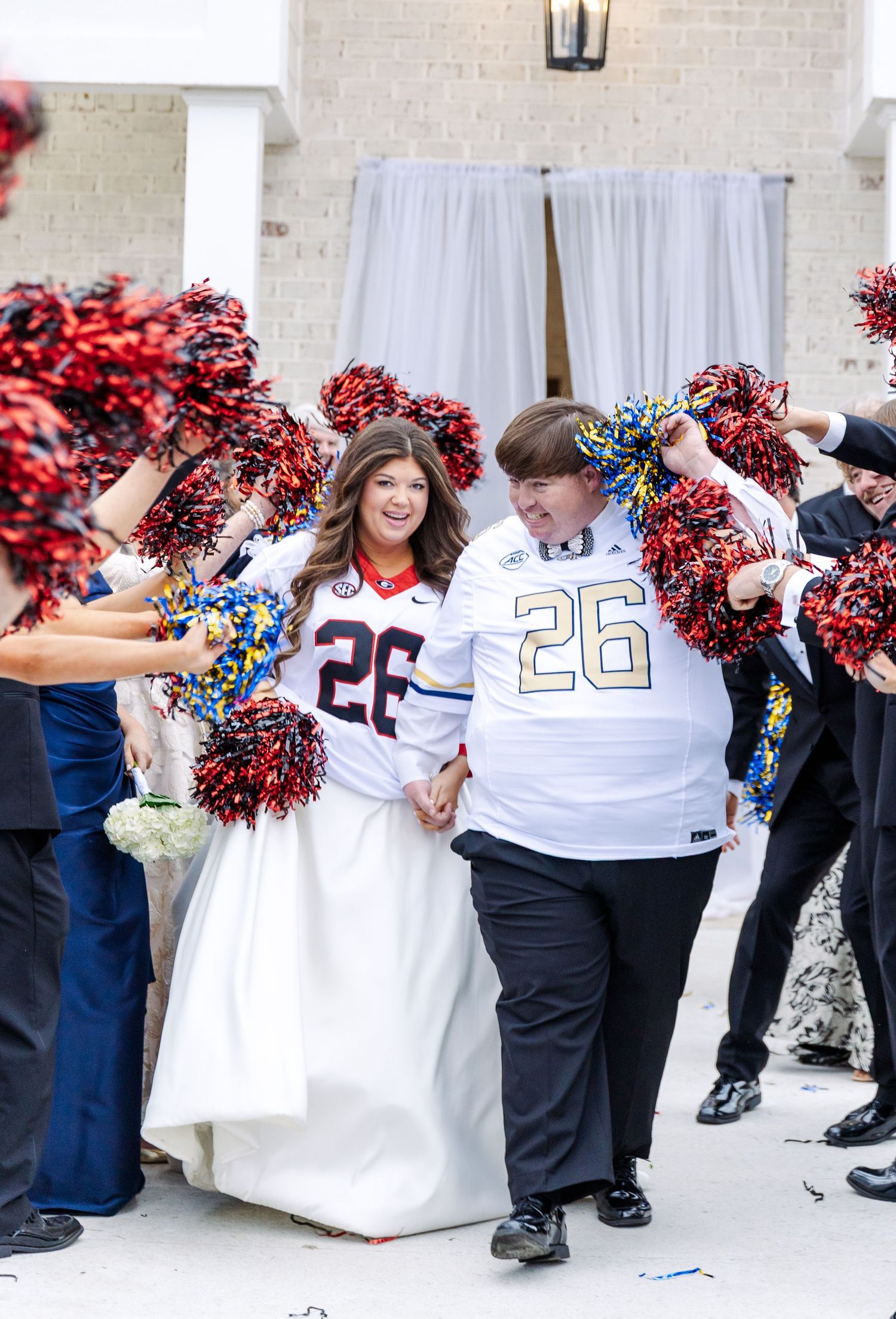 Bride and groom wearing matching number 26 football jerseys celebrate during fun wedding recessional.