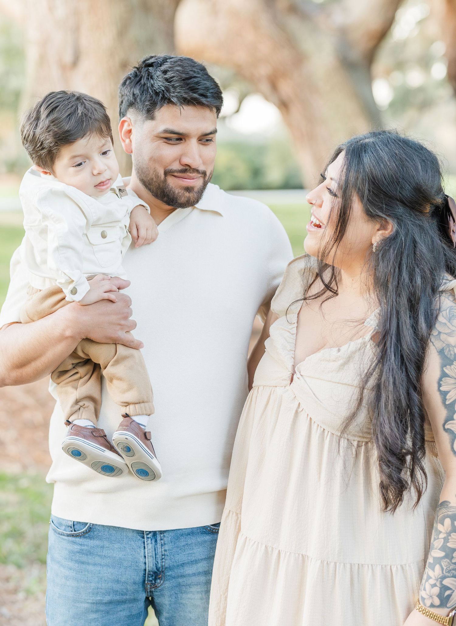Family enjoying a tender moment together outdoors in casual attire during a photo session.