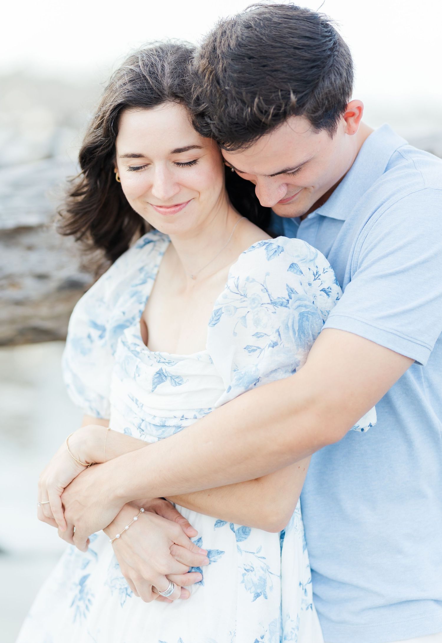 An intimate embrace captured in soft dreamy light on the beach.