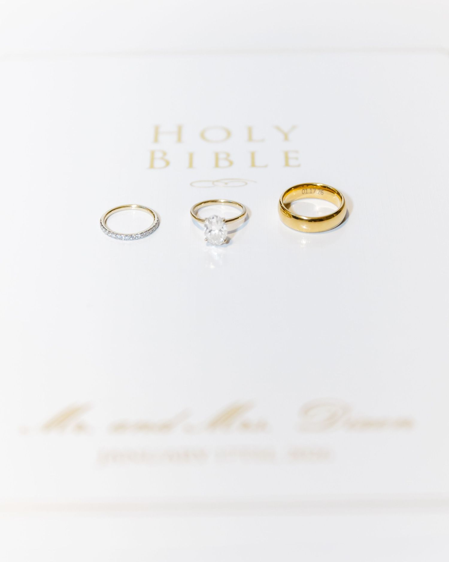 Wedding rings and Holy Bible arranged on white background with soft focus.