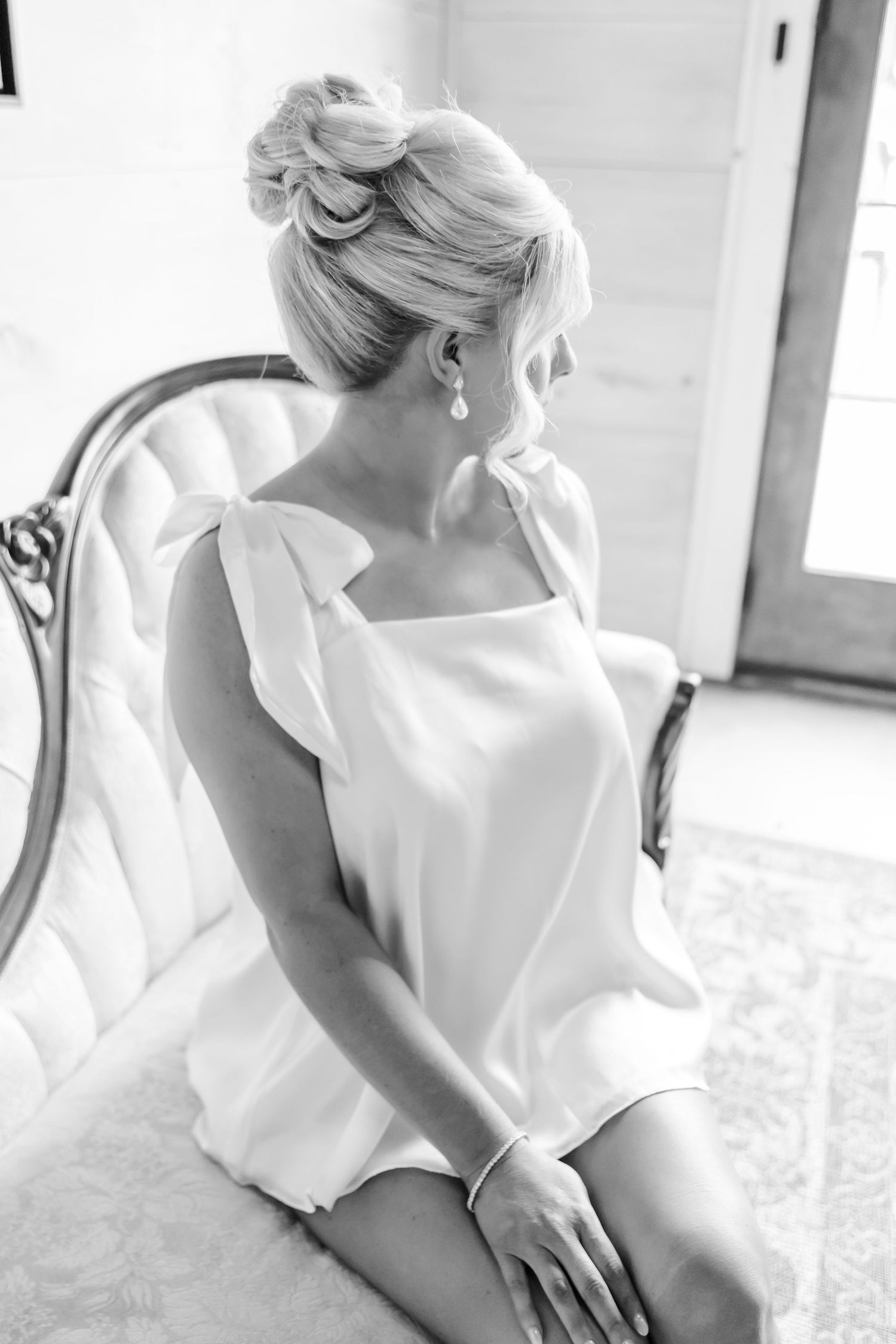 A bride in an elegant white wedding dress is captured in a series of soft, romantic black and white photographs.