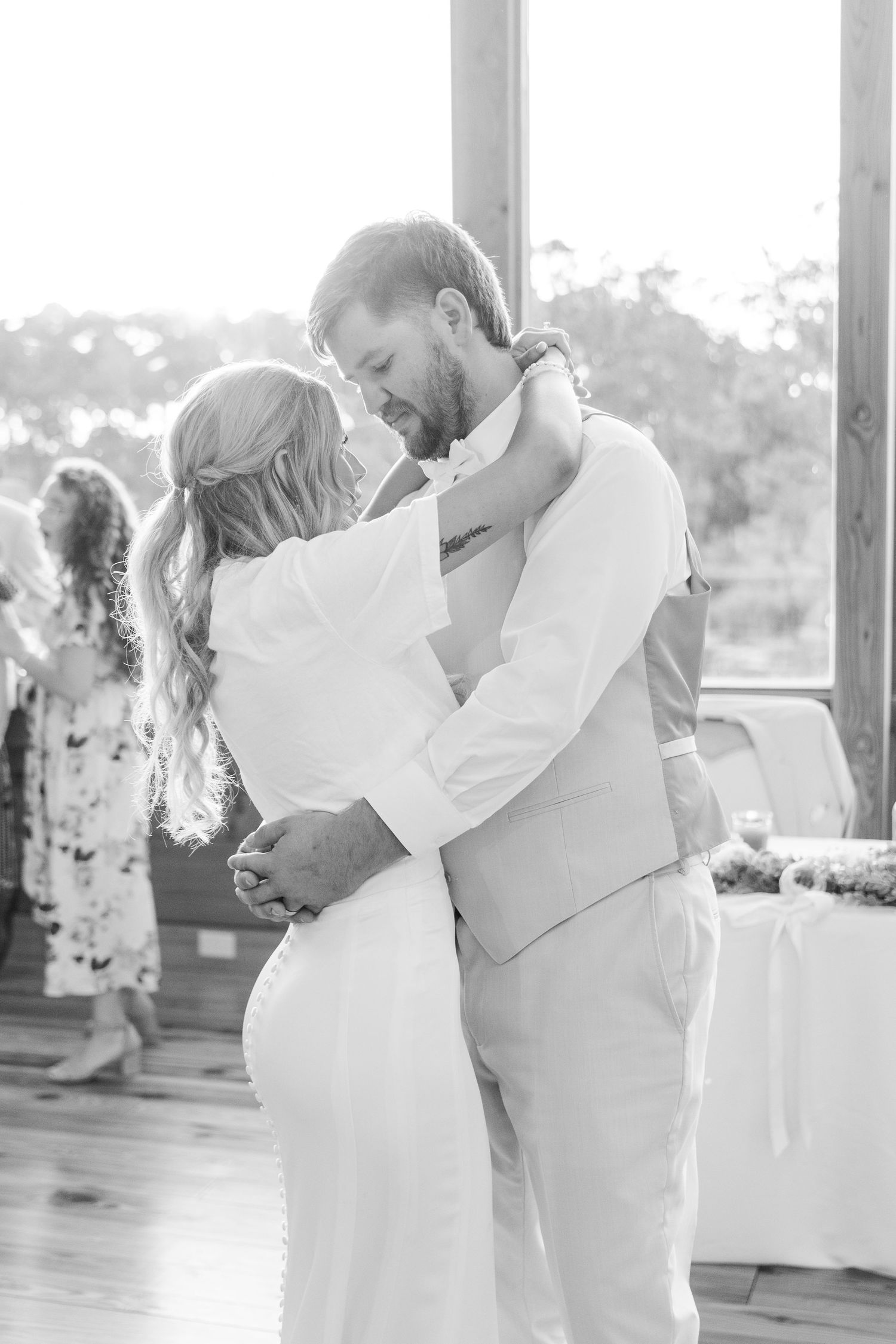 Elegant first dance between newlyweds in white attire during their wedding reception.