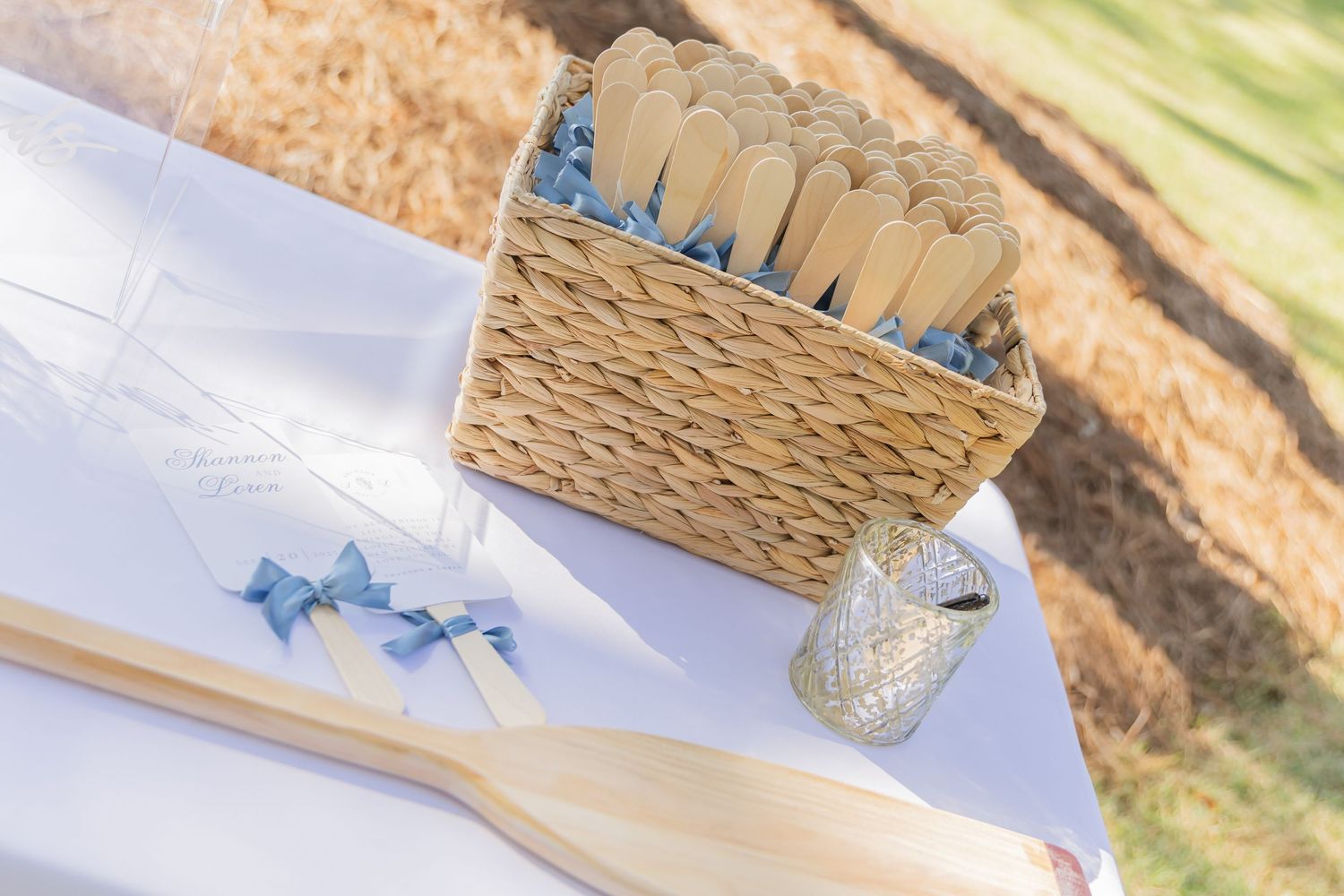 Woven baskets and decorative elements arranged on a white surface for an outdoor event.