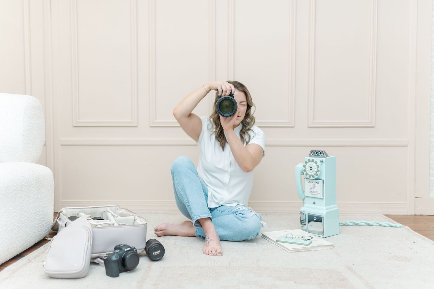 Minimalist home decor arrangement with teal and white ceramic vases, teapots and bowls on light wooden floor.