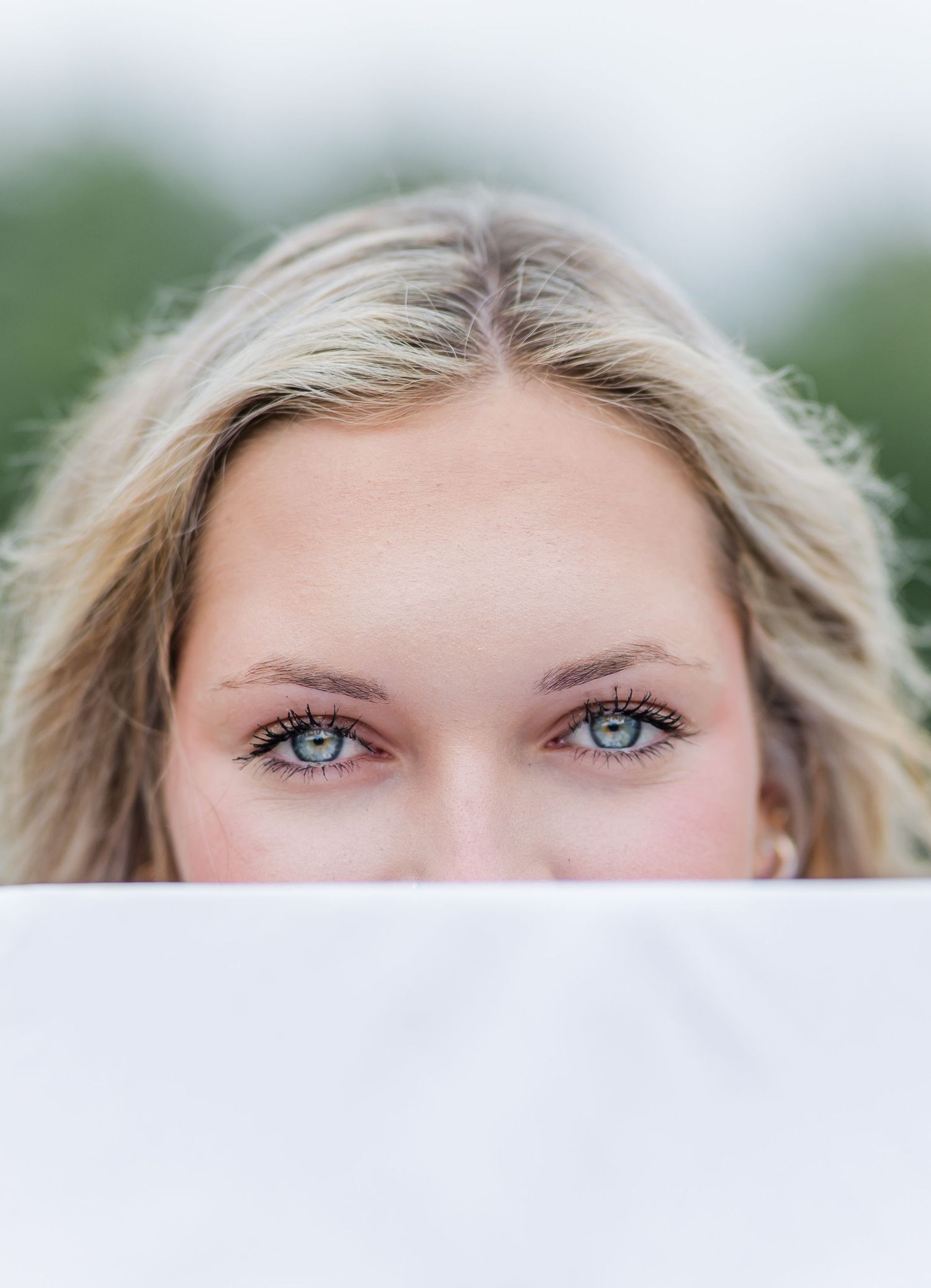 Close up portrait of striking blue eyes and blonde hair against a soft blurred background.